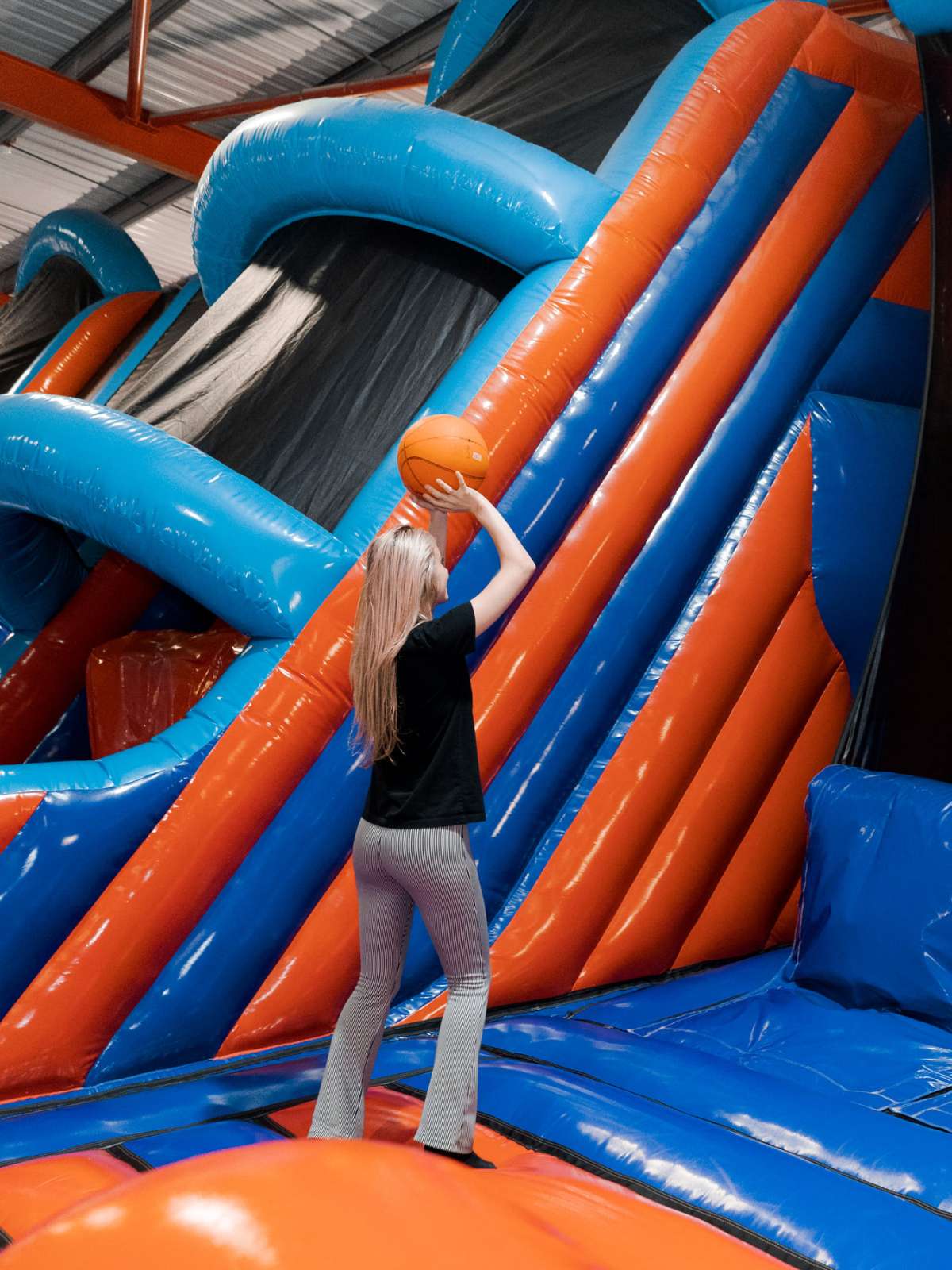 Girl on inflatable throwing basketball