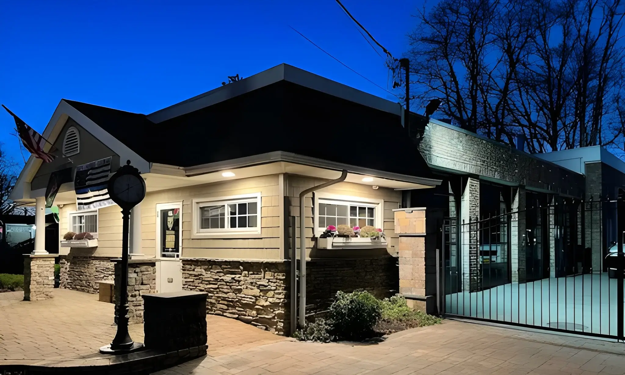 A small house with a black roof and a gate.