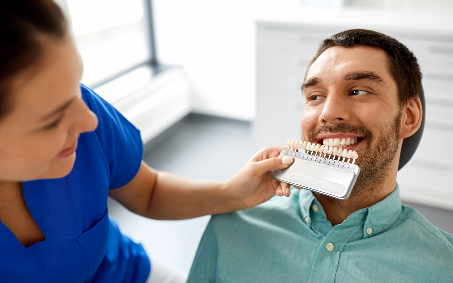 A dental assistant matches a patient’s tooth color for veneers at the best dentist in Los Gatos