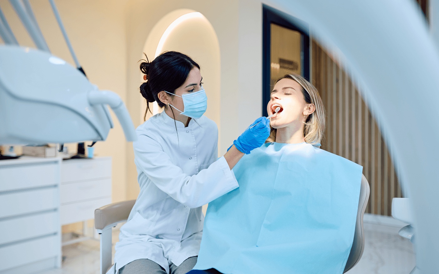 Dentist performing oral exam and gum disease treatment on patient in modern dental office, highlighting care from the best dentist in Los Gatos, CA