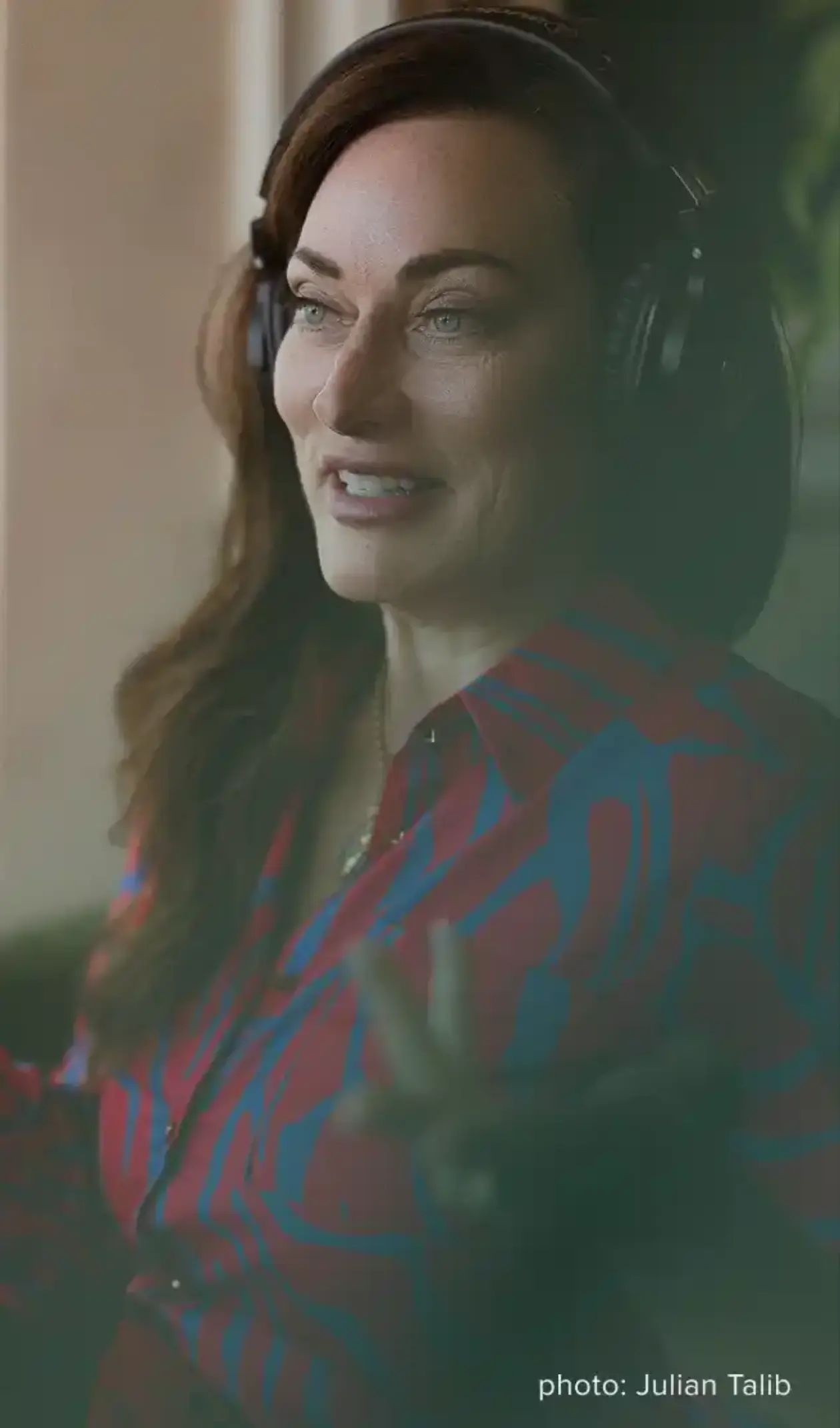 A woman with dark hair, possibly Theo Crain from The Haunting of Hill House, is smiling in a headshot