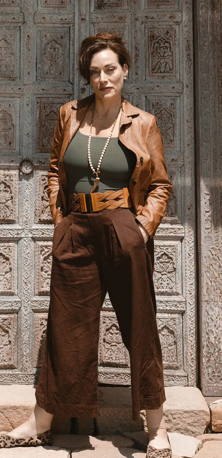 "An artistic shot featuring a woman with flowing brown hair in a red garment, captured with a dark and textured background