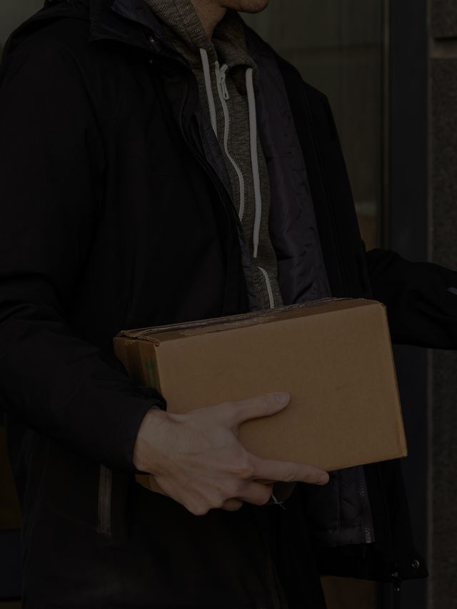 Plain unmarked package held at a doorway