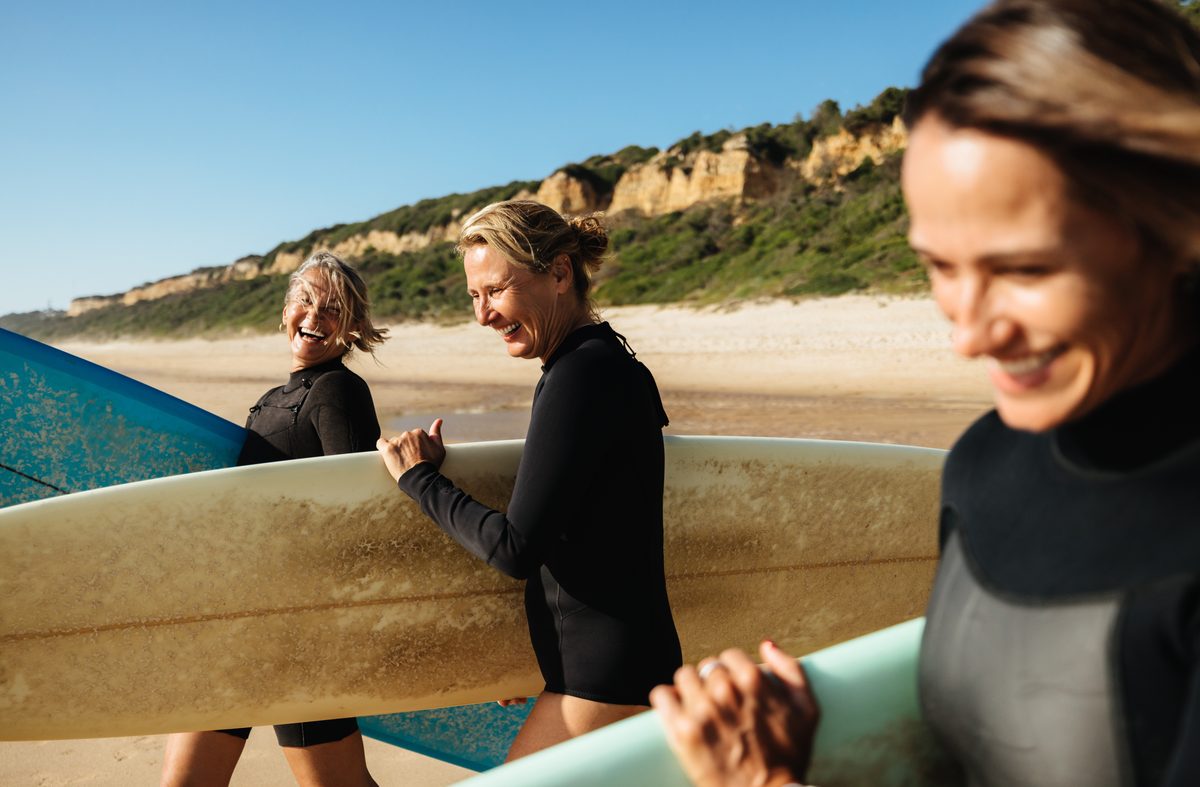 Friends with surfboards on the beach