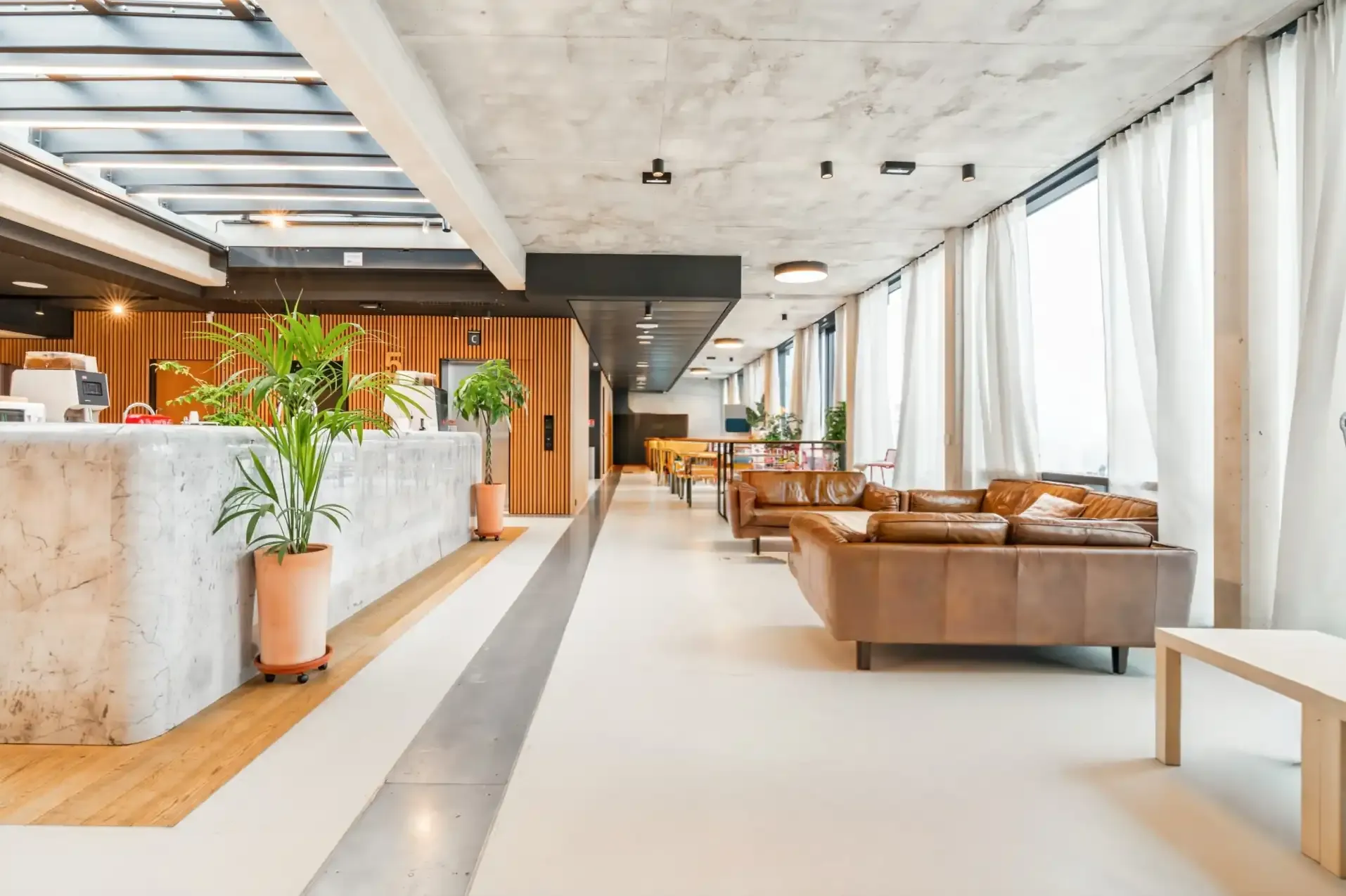 bureau avec des canapés marrons devant une réception d'accueil