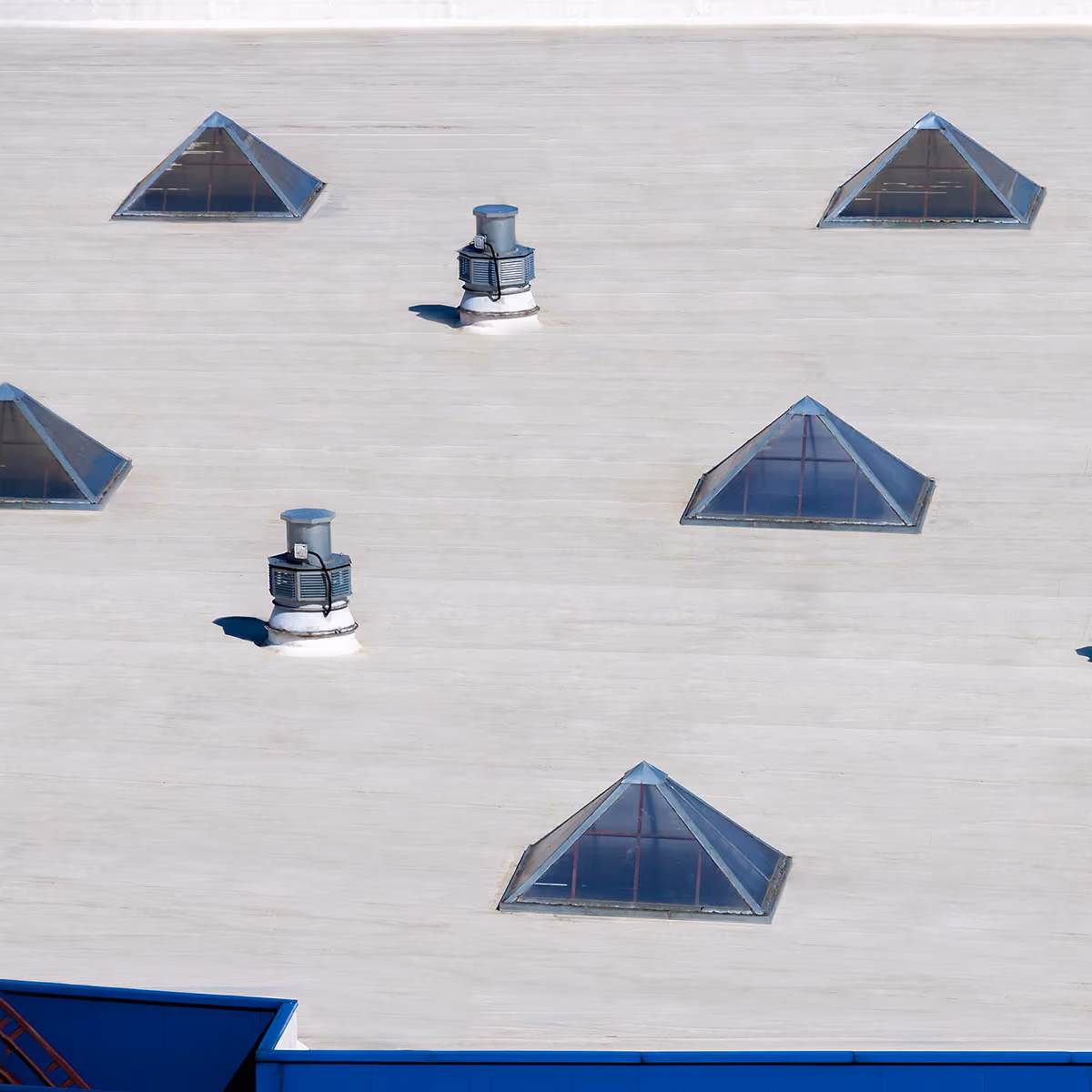 White commercial flat roof with skylights and vents