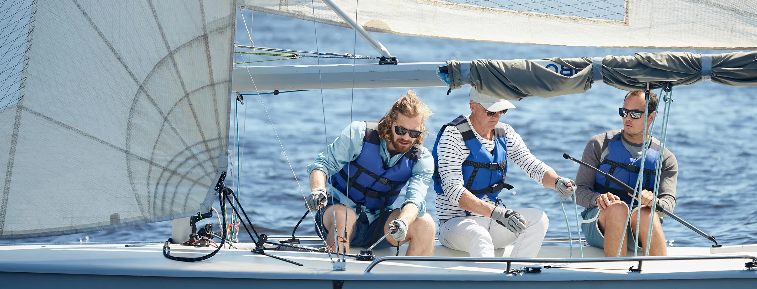 Three people on a boat in safety vests