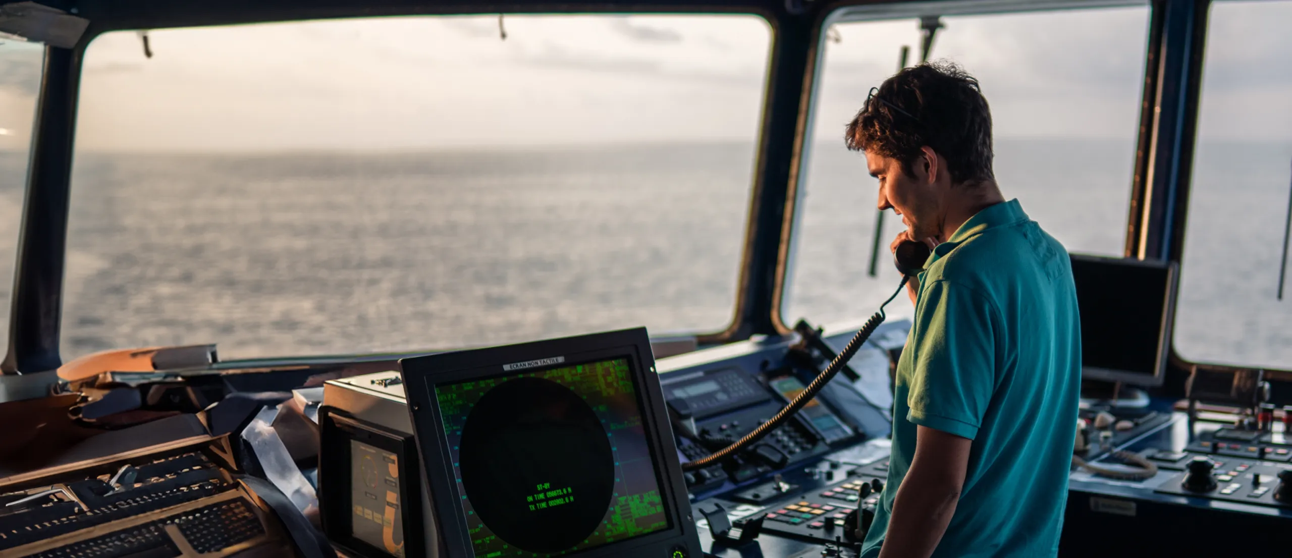 A man in a ships control room talking on the phone