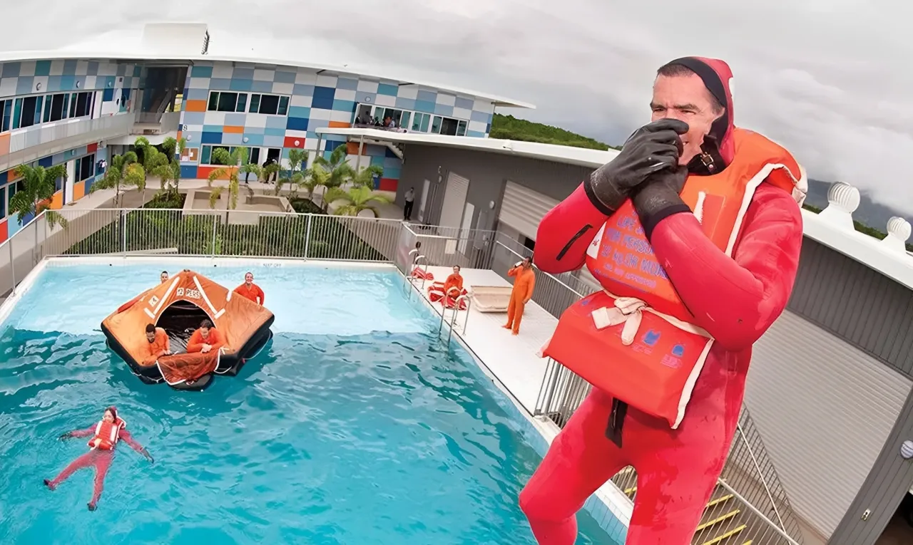 People in a training pool with a scuba gear. One of them is jumping in the pool.