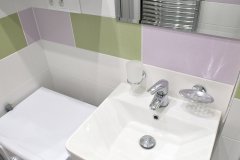Detail umyvadla s jemně barevnými kachličkami
