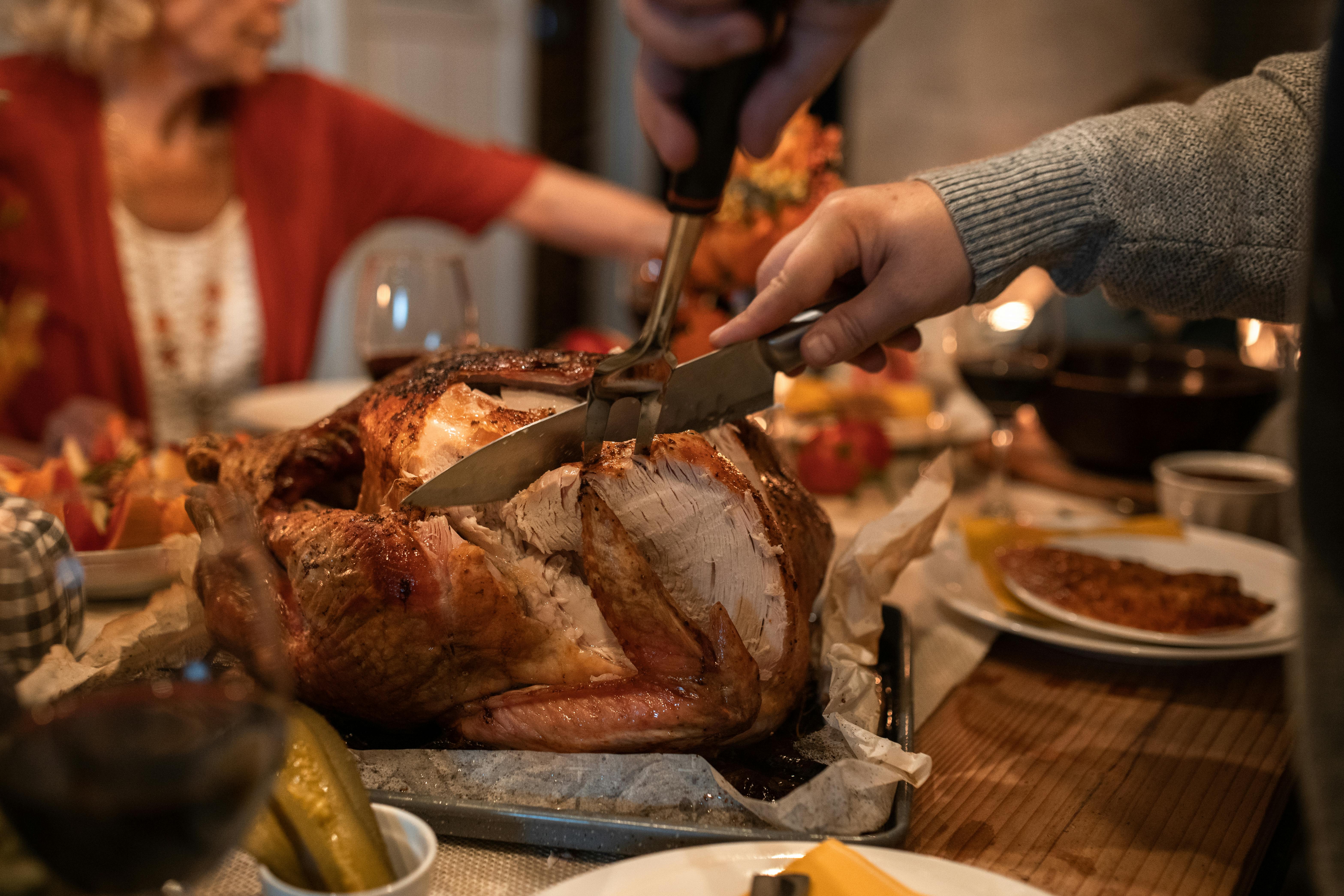 Person carving turkey at the table