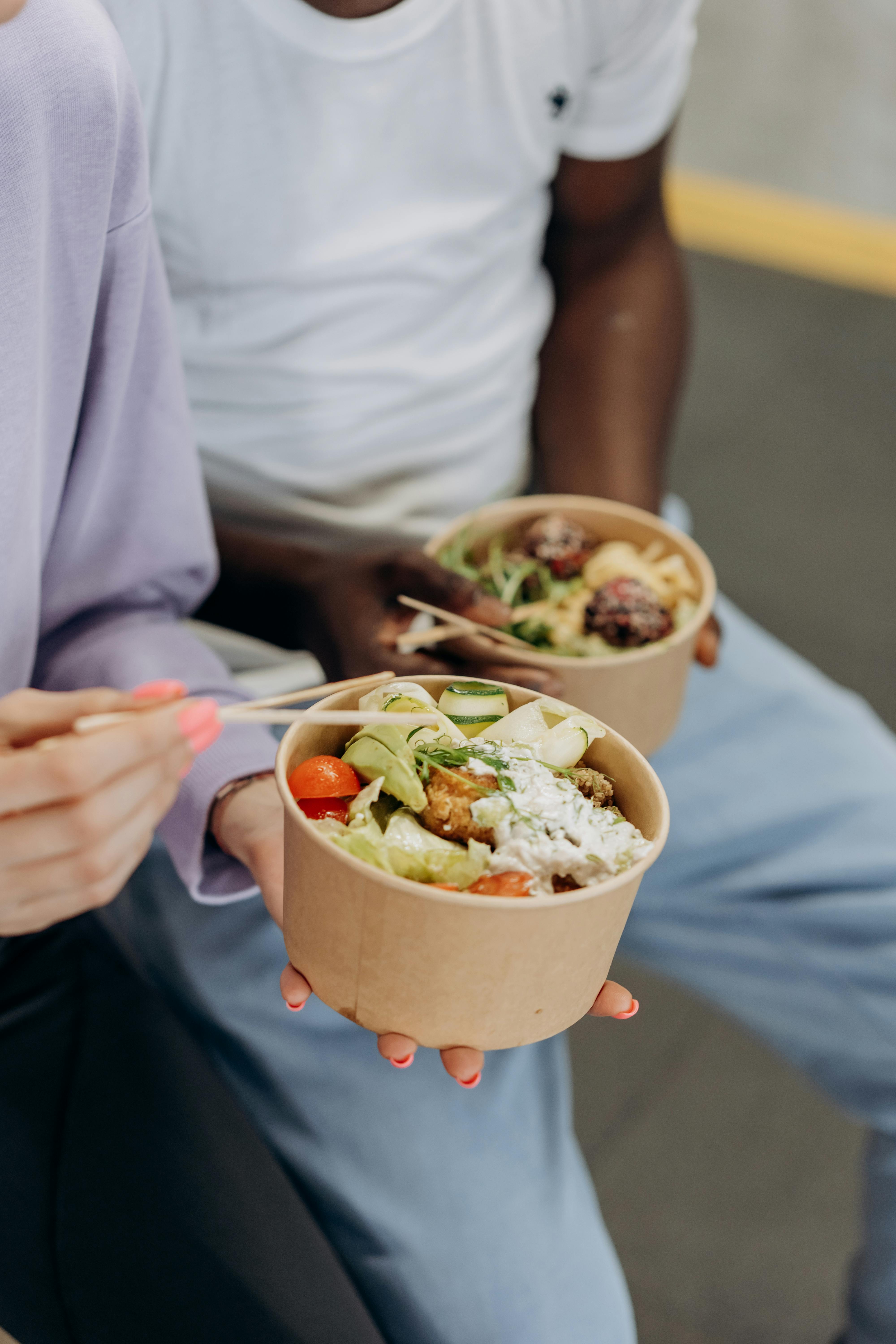 Two people eating protein bowls