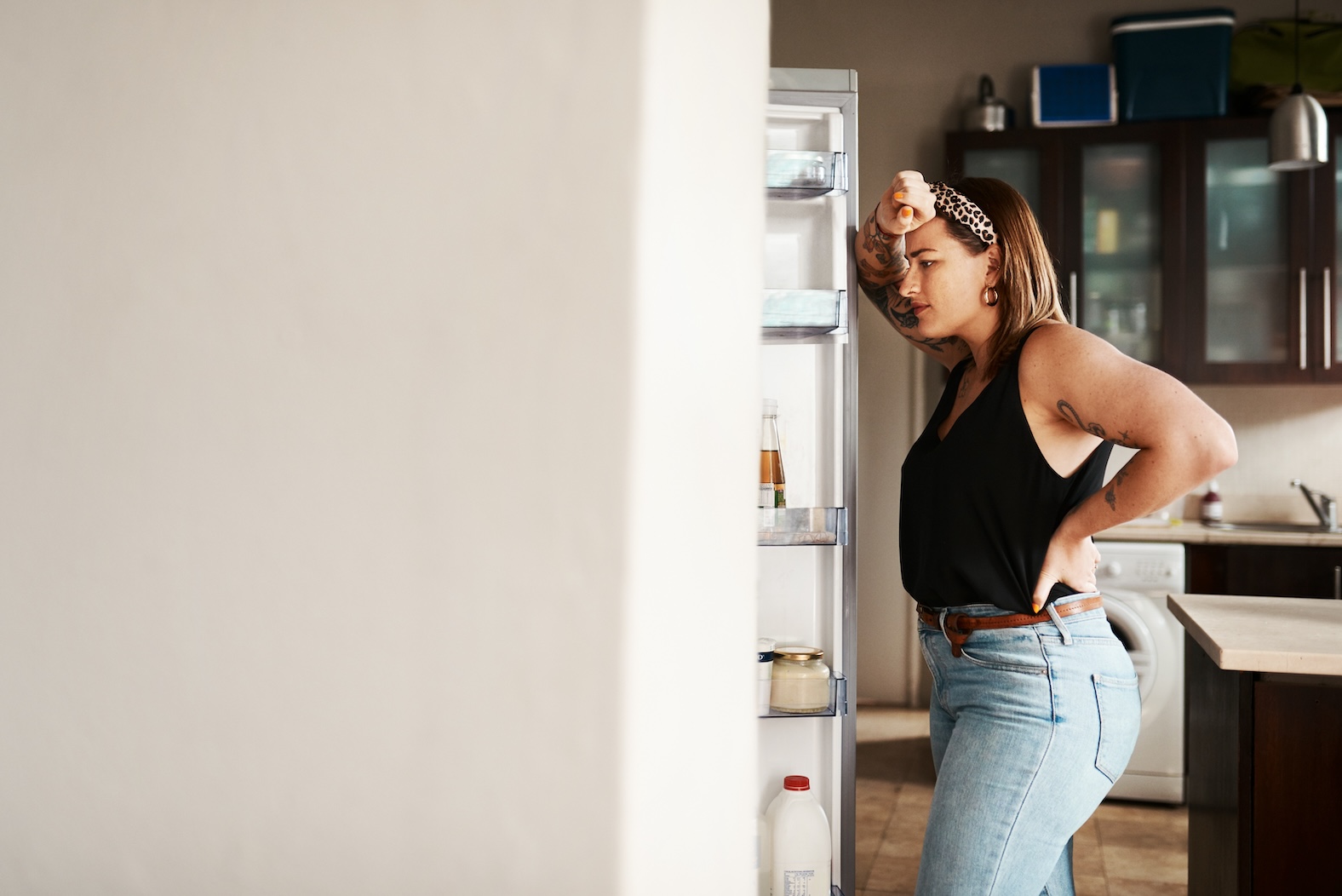 Woman standing in front of open fridge