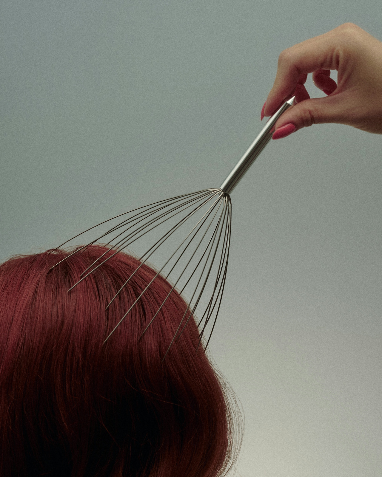 Person using wire massager on head