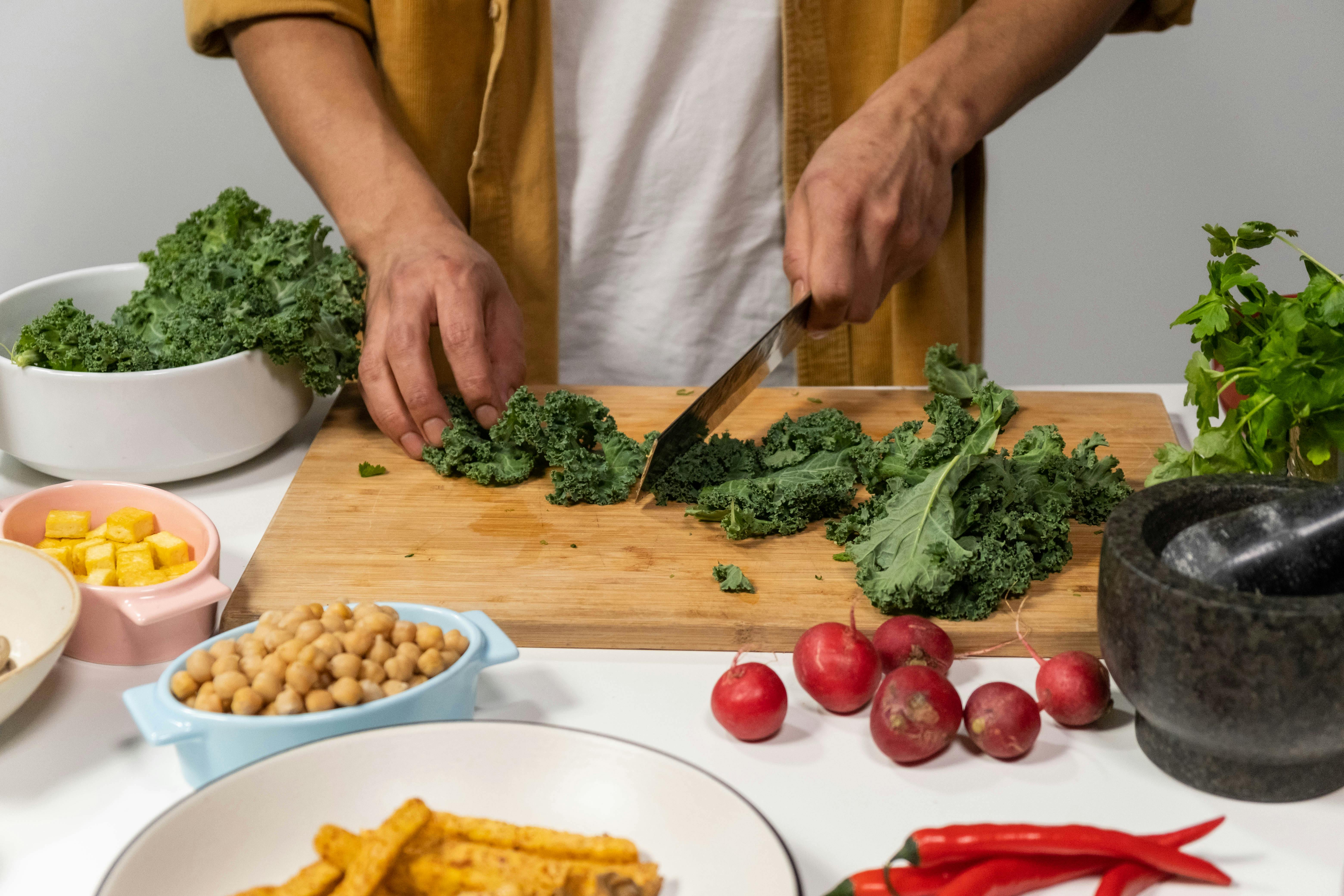 Man cutting kale on breadboard