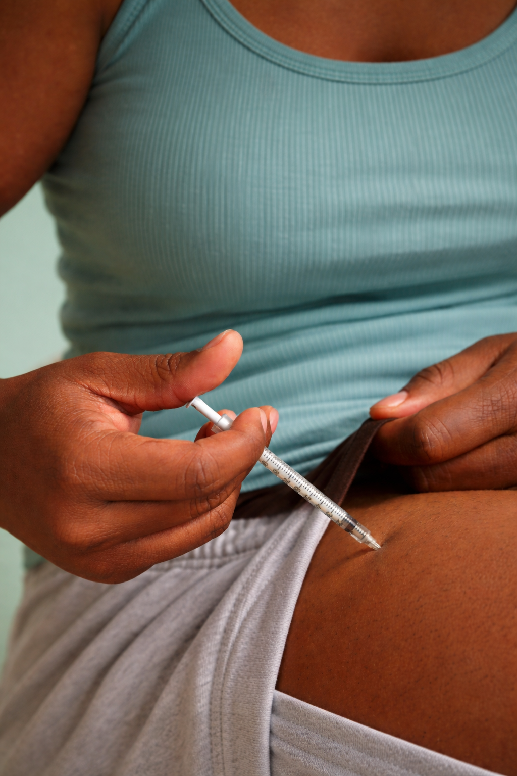Person injecting needle into thigh