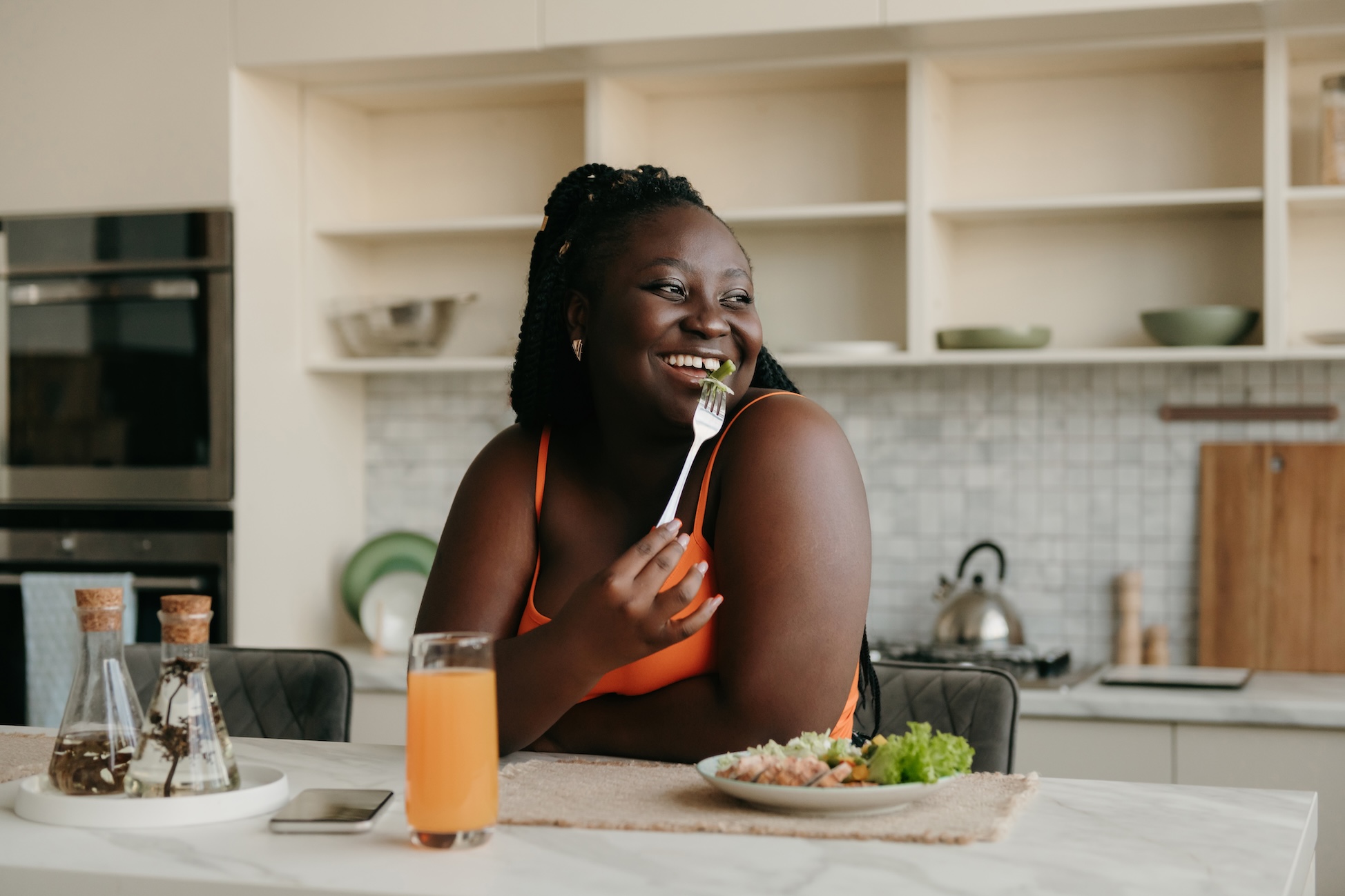 Woman smiling while eating salad