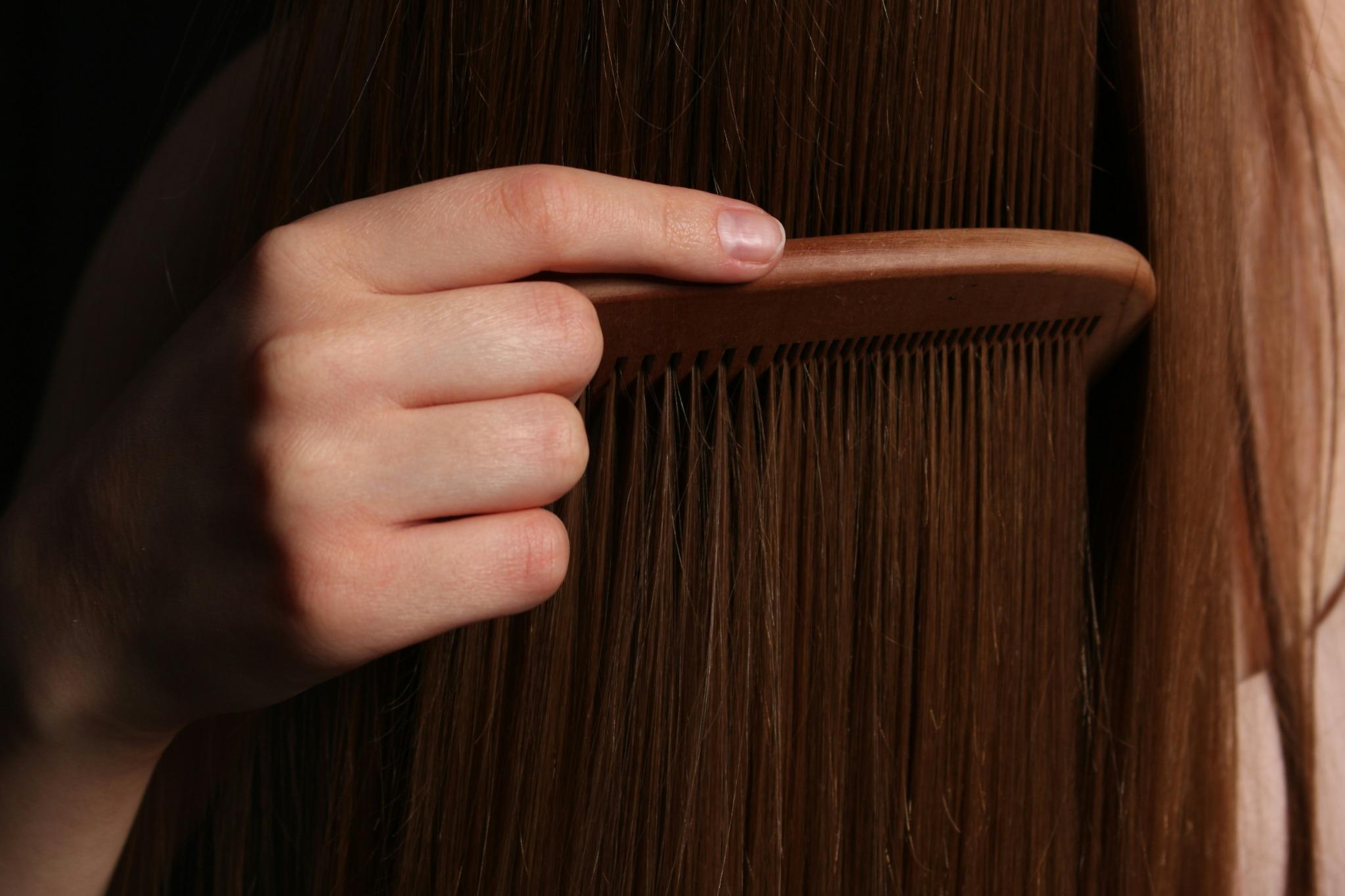 Running comb through long brown hair
