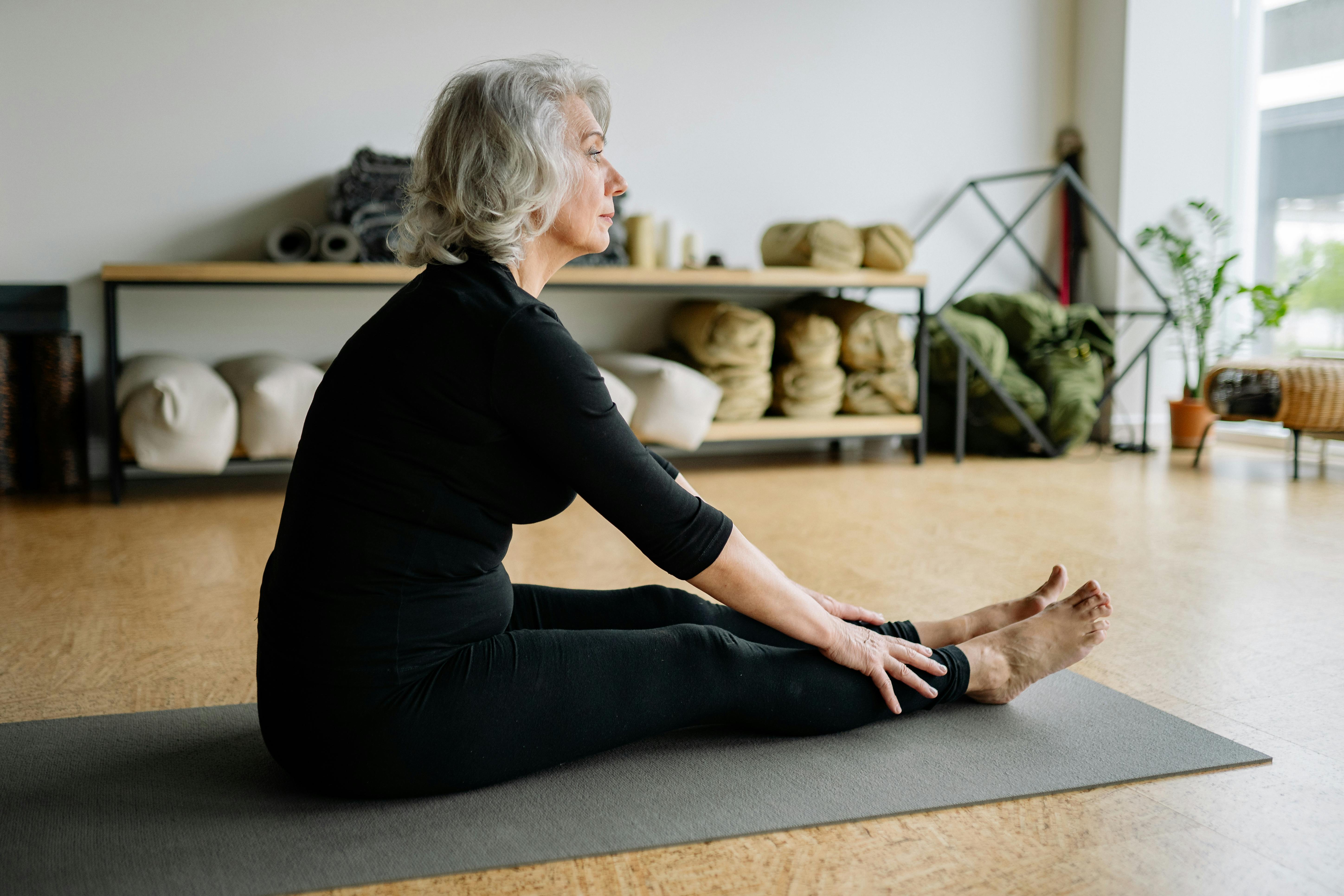Older woman stretching on yoga mat