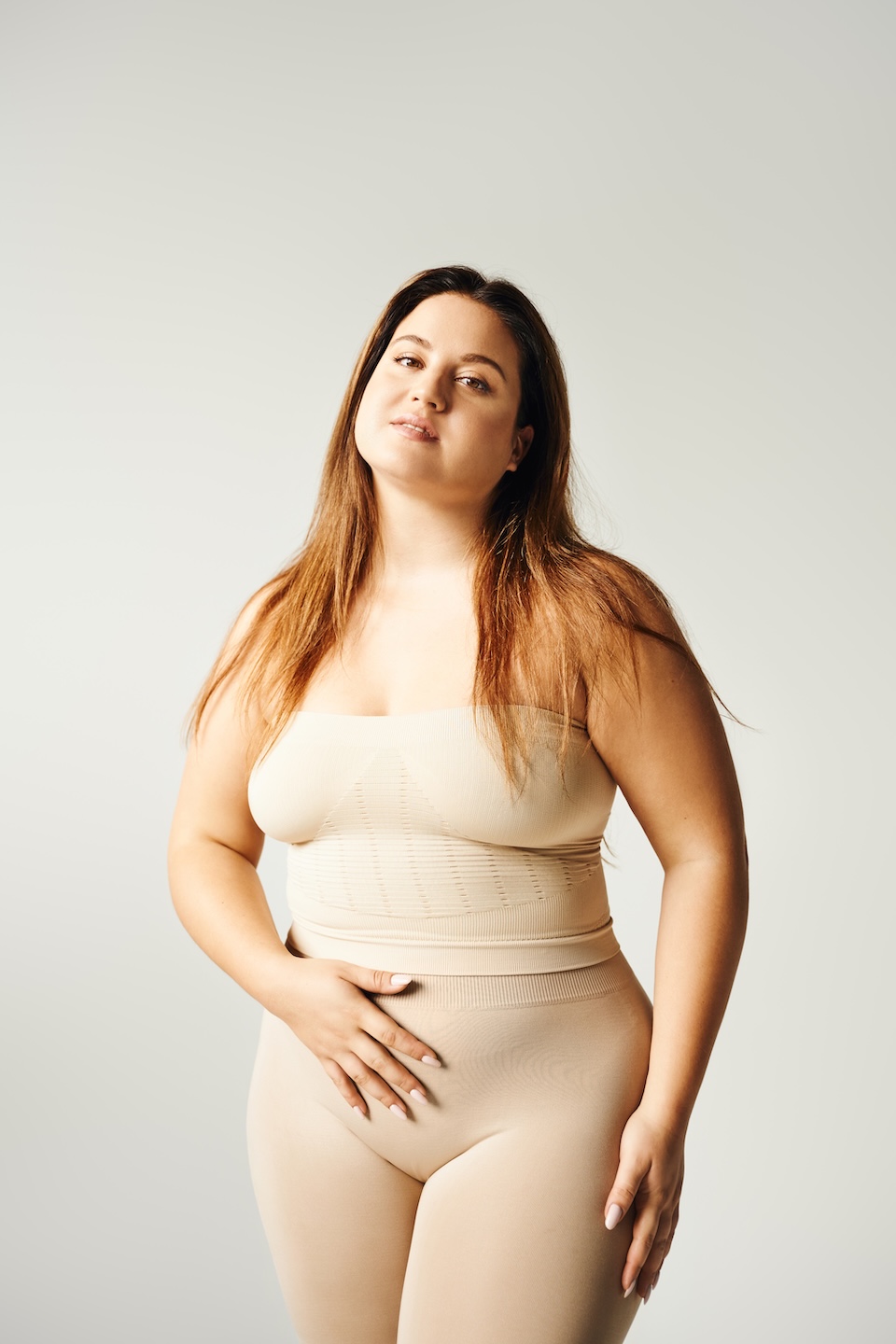 Plus size woman with long hair wearing tan underclothes