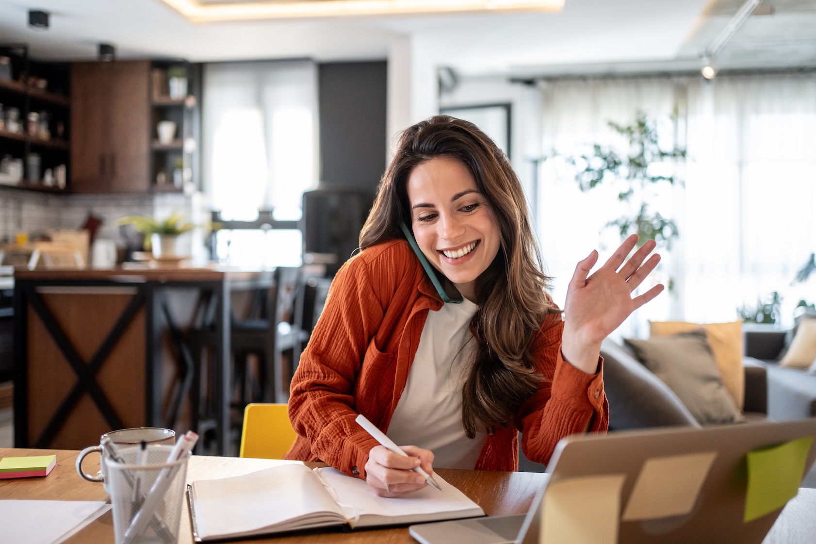 Woman taking notes while on a video call