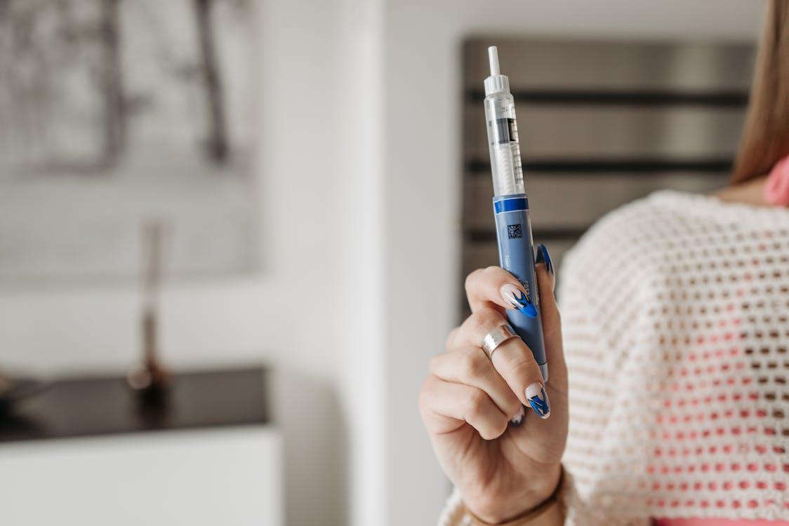 Woman holding an injectable blue pen for diabetes management