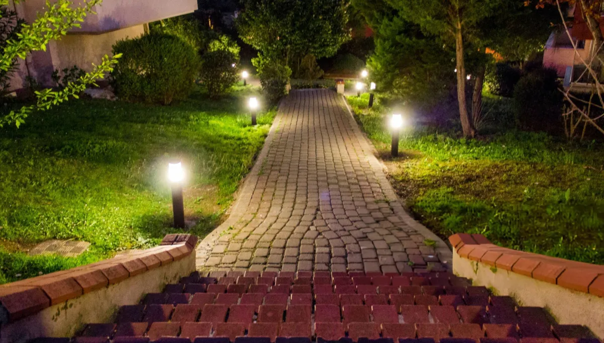 Brick garden walkway illuminated by landscape lighting
