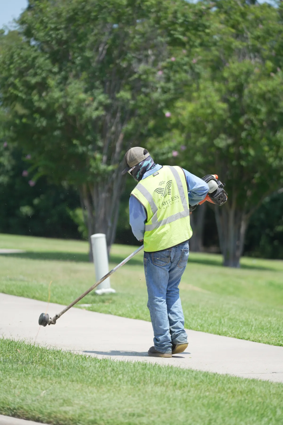 Landscaping crew member edging a lawn