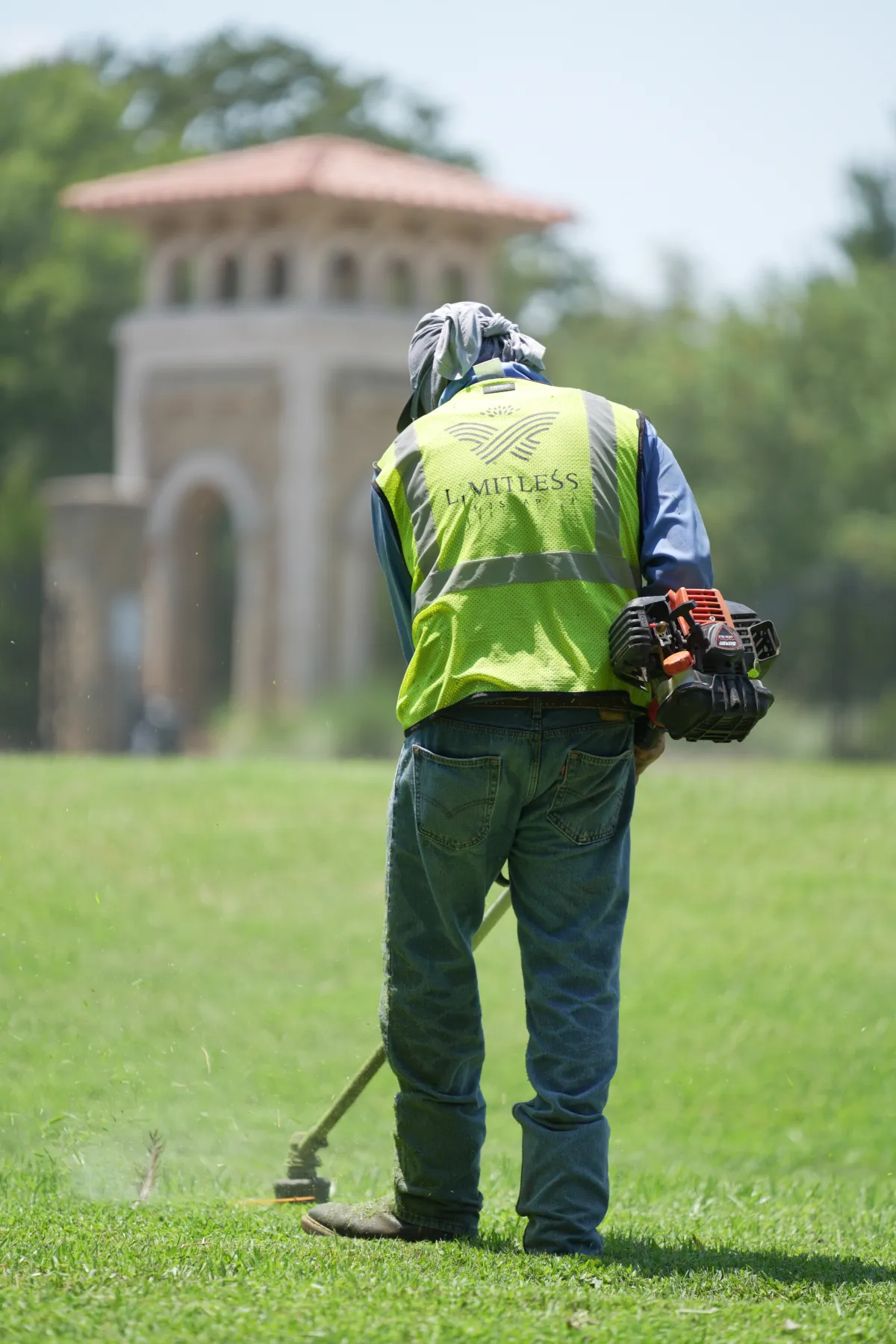Landscaping crew member using a backpack leaf blower