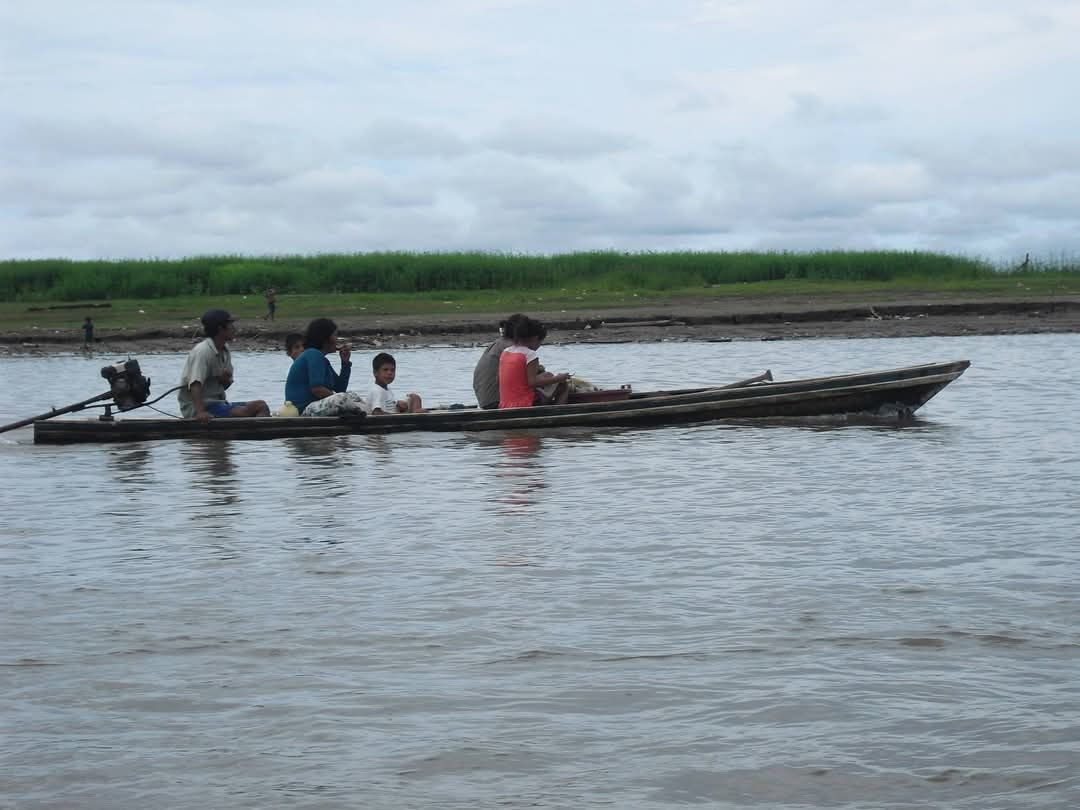 An indigenous family navigating the Amazon River in Peru