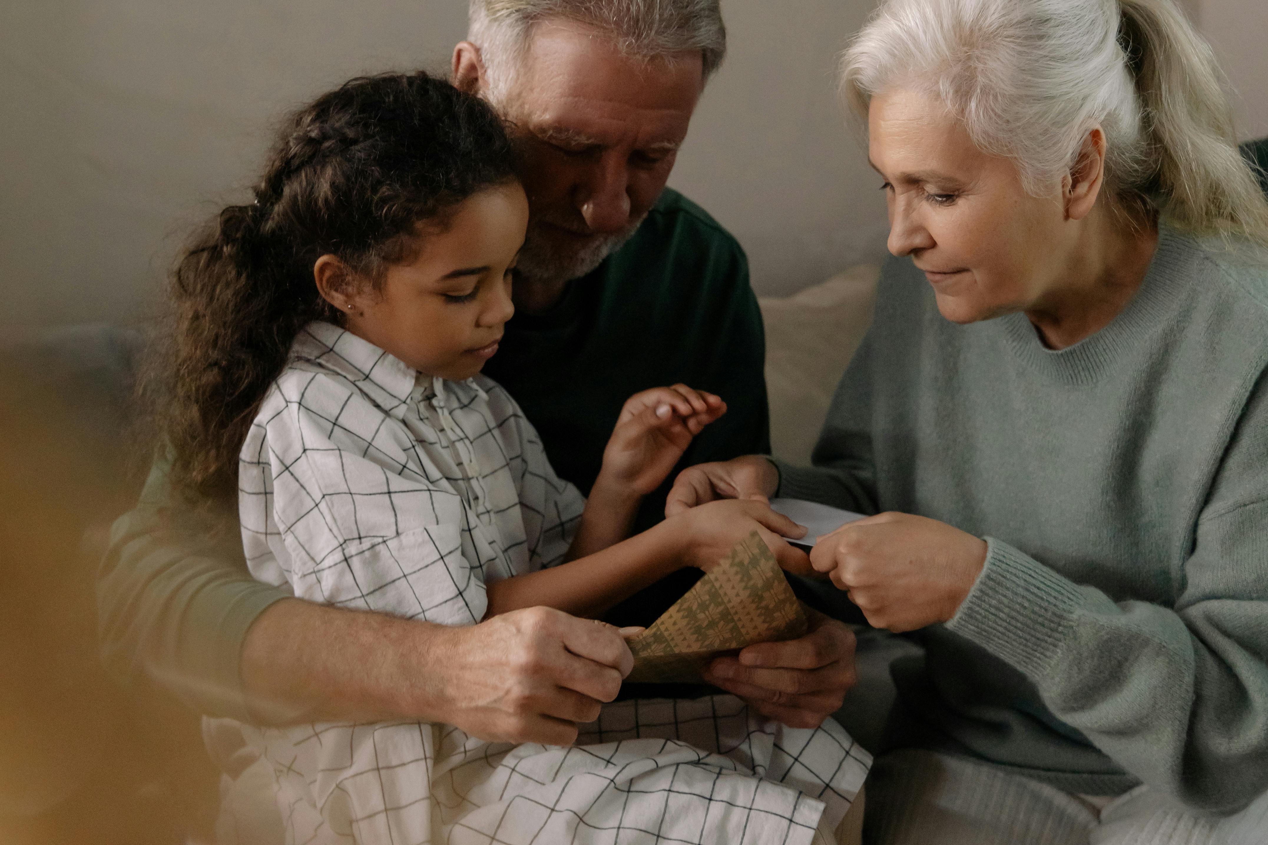 grandparents showing their granddaughter a picture