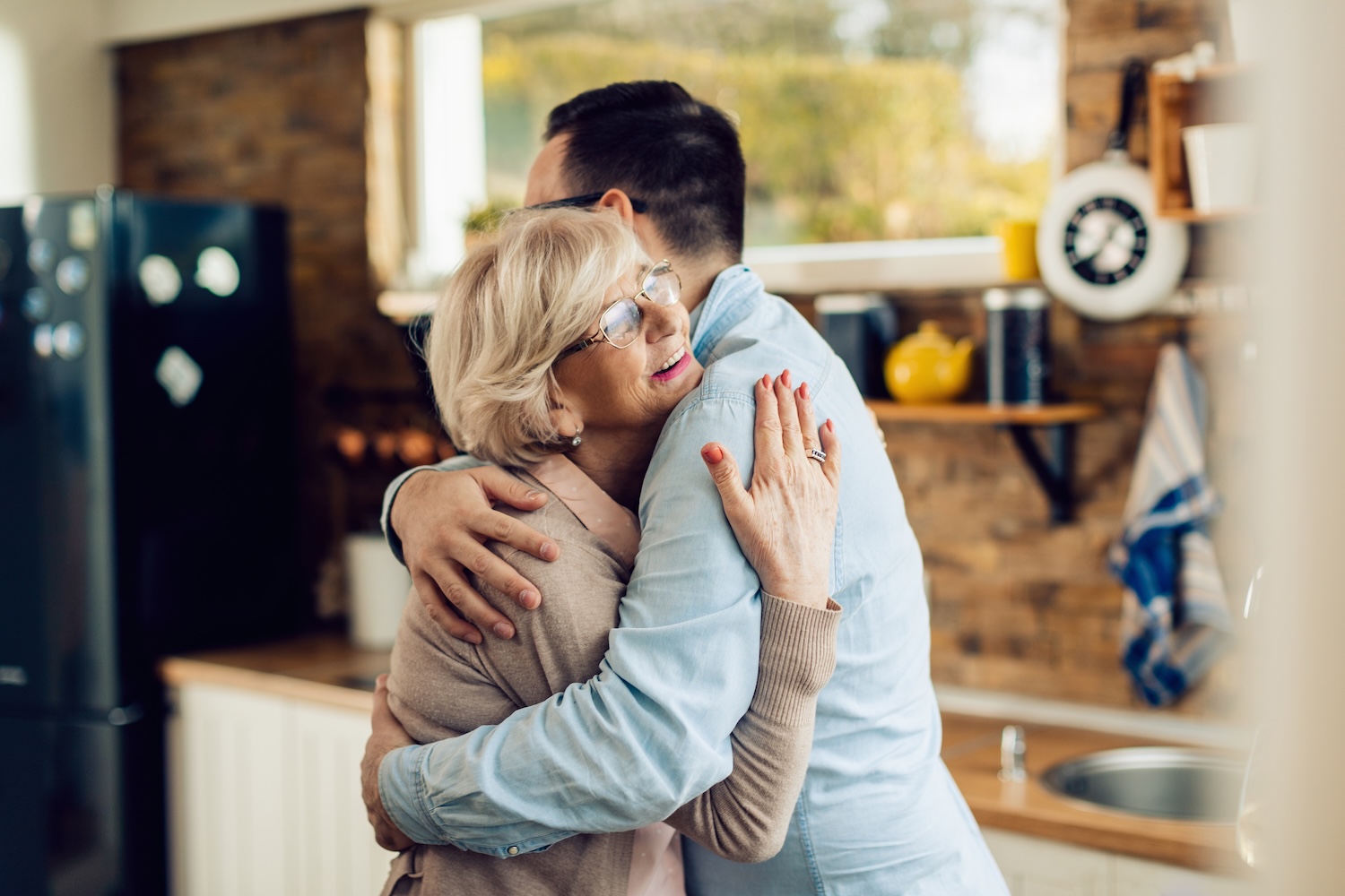 older mom hugging adult son