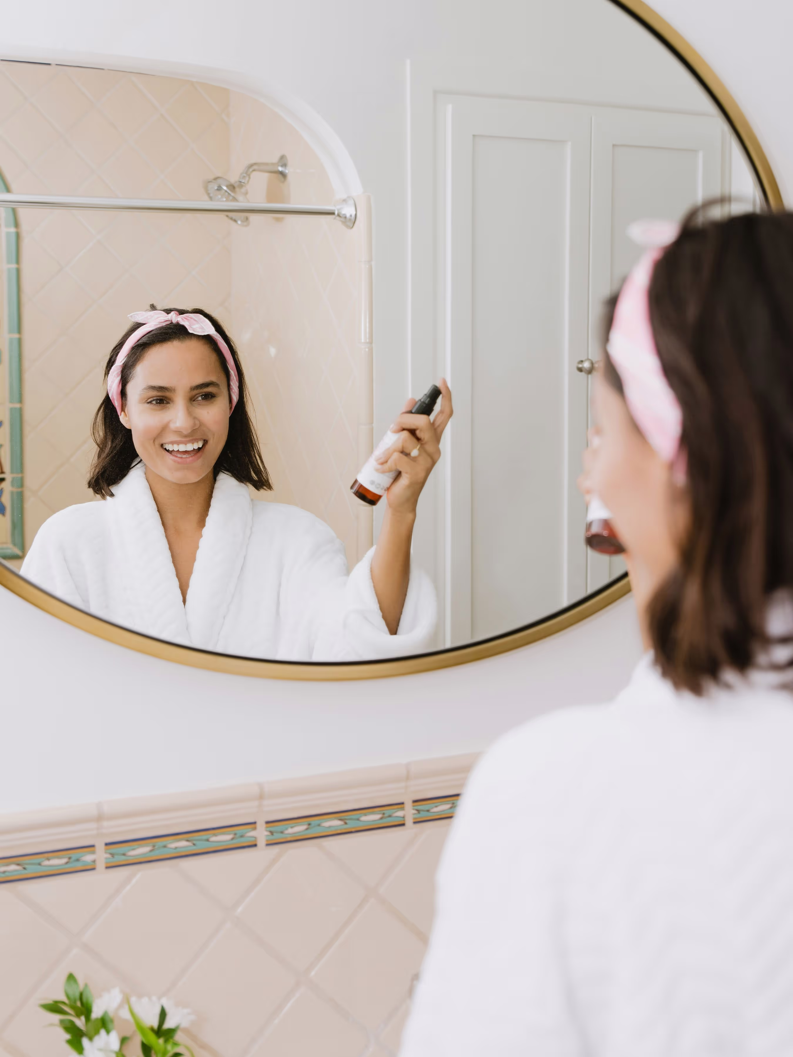 A woman brushing her teeth in front of a mirror.