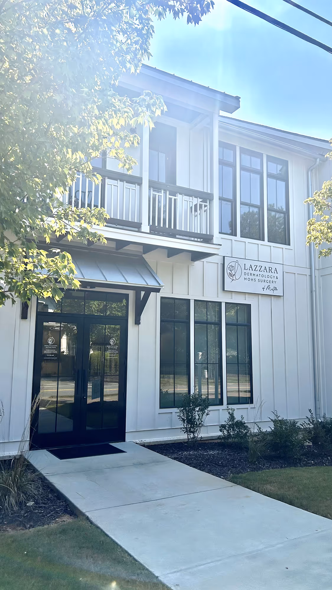 A white building with a black door and windows.