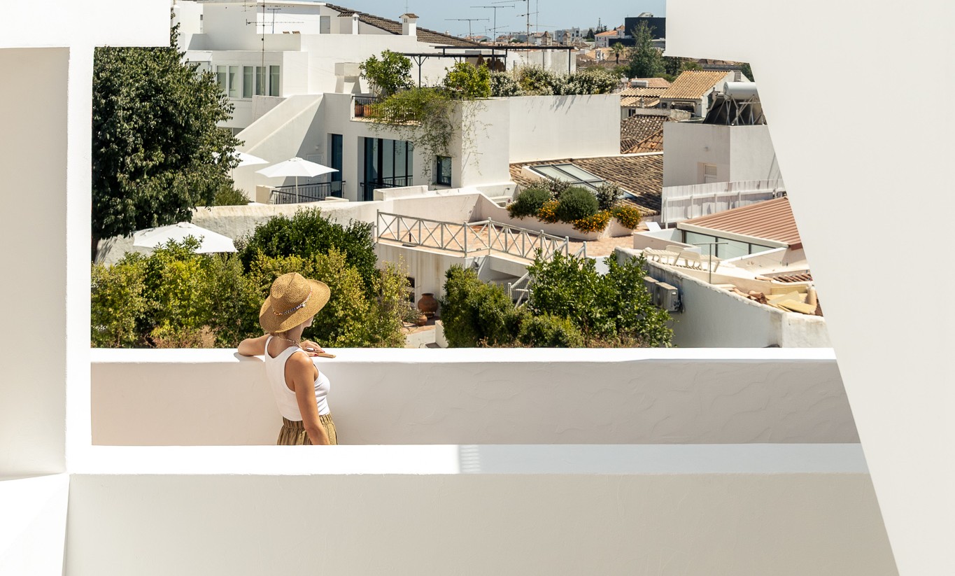 View over the rooftops of Tavira with traditional tiled buildings and sunlit facades – Palacio de Tavira