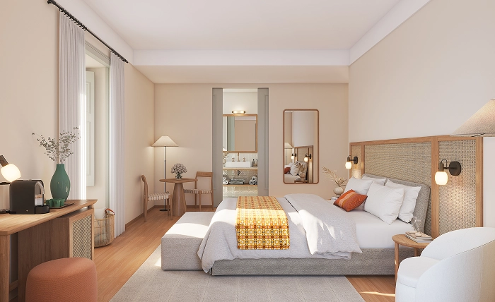 Spacious and modern junior suite with a sunlit king-sized bed, orange-accented linens, a desk with a coffee machine, and a bathroom visible through open sliding doors - Palacio de Tavira