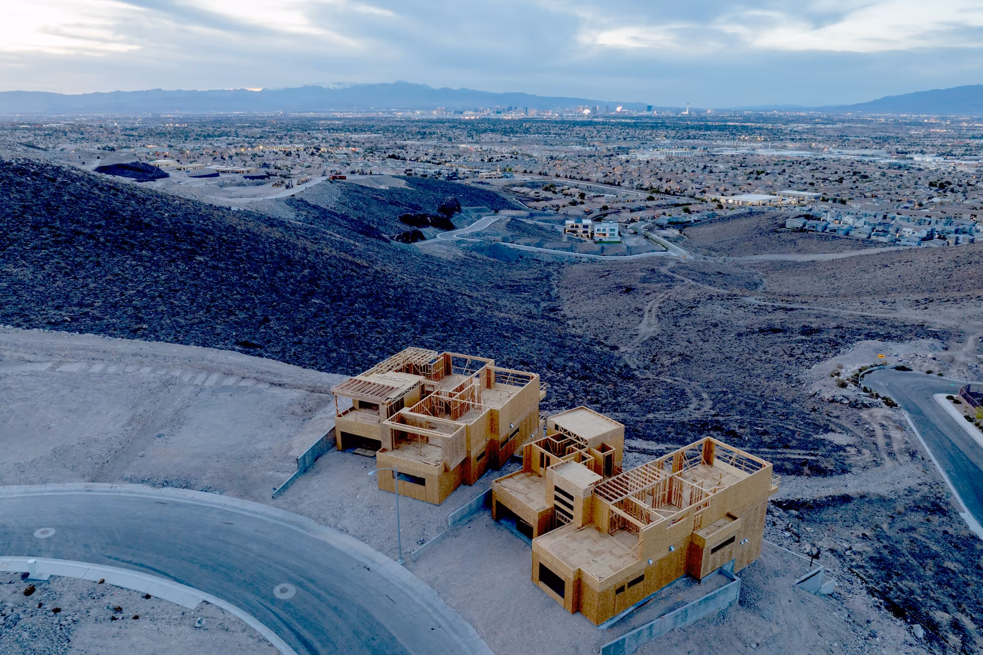 A full view of the Alta Vista development lot at dusk with Las Vegas lights in the distance