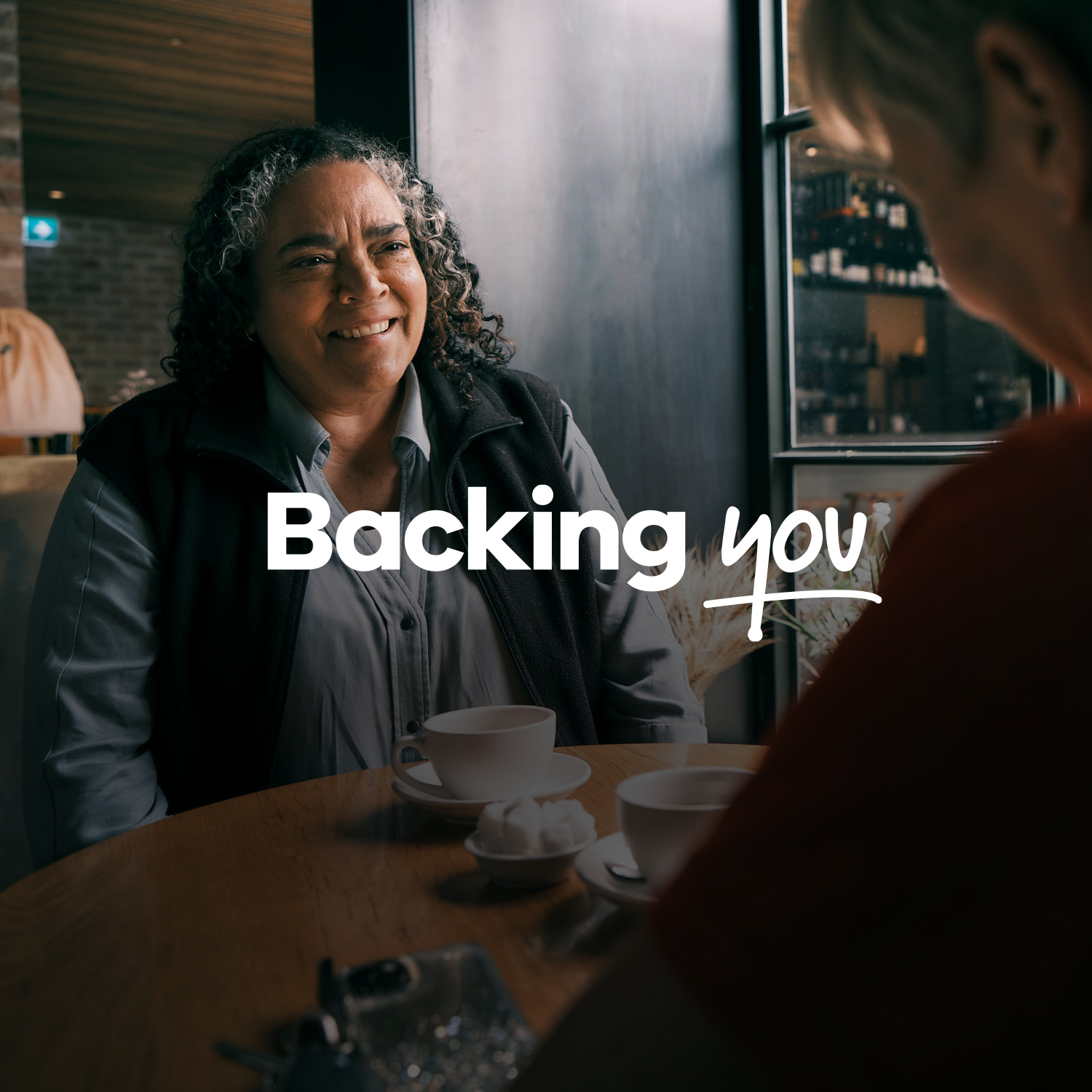 Woman sits at cafe - Backing you