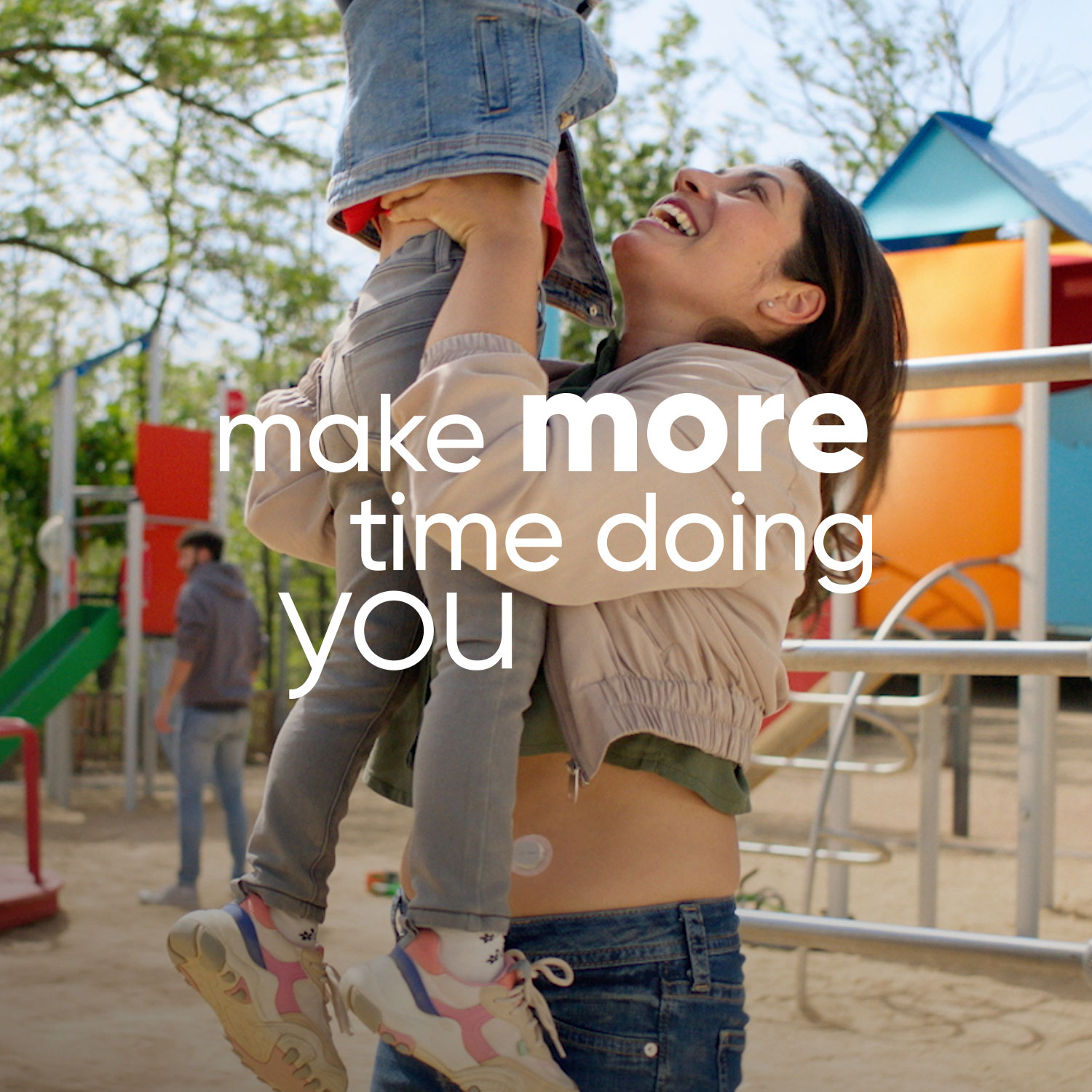 Woman wearing Dexcom sensor lifts child in playground