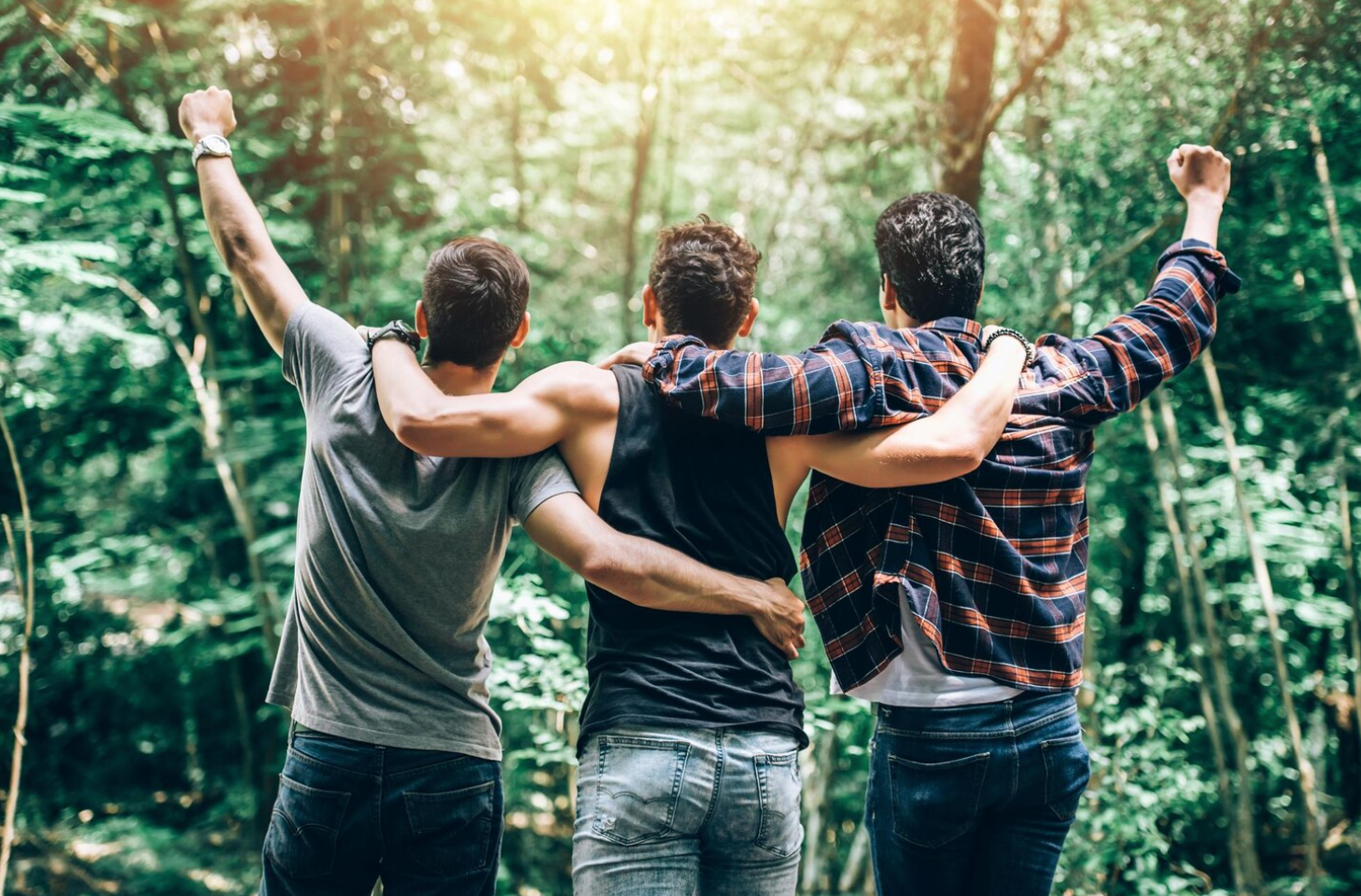Three friends, in a forest setting, celebrate recovery and support, showing that overcoming being addicted to prescription drugs is possible with the right help