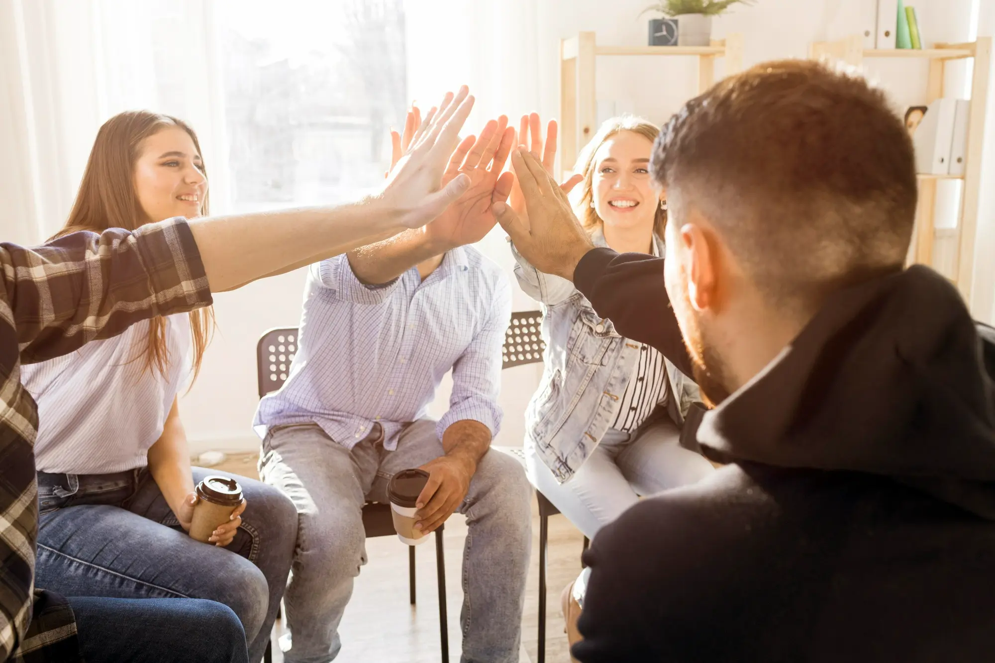 Recovery group members celebrating progress and supporting one another during a meeting