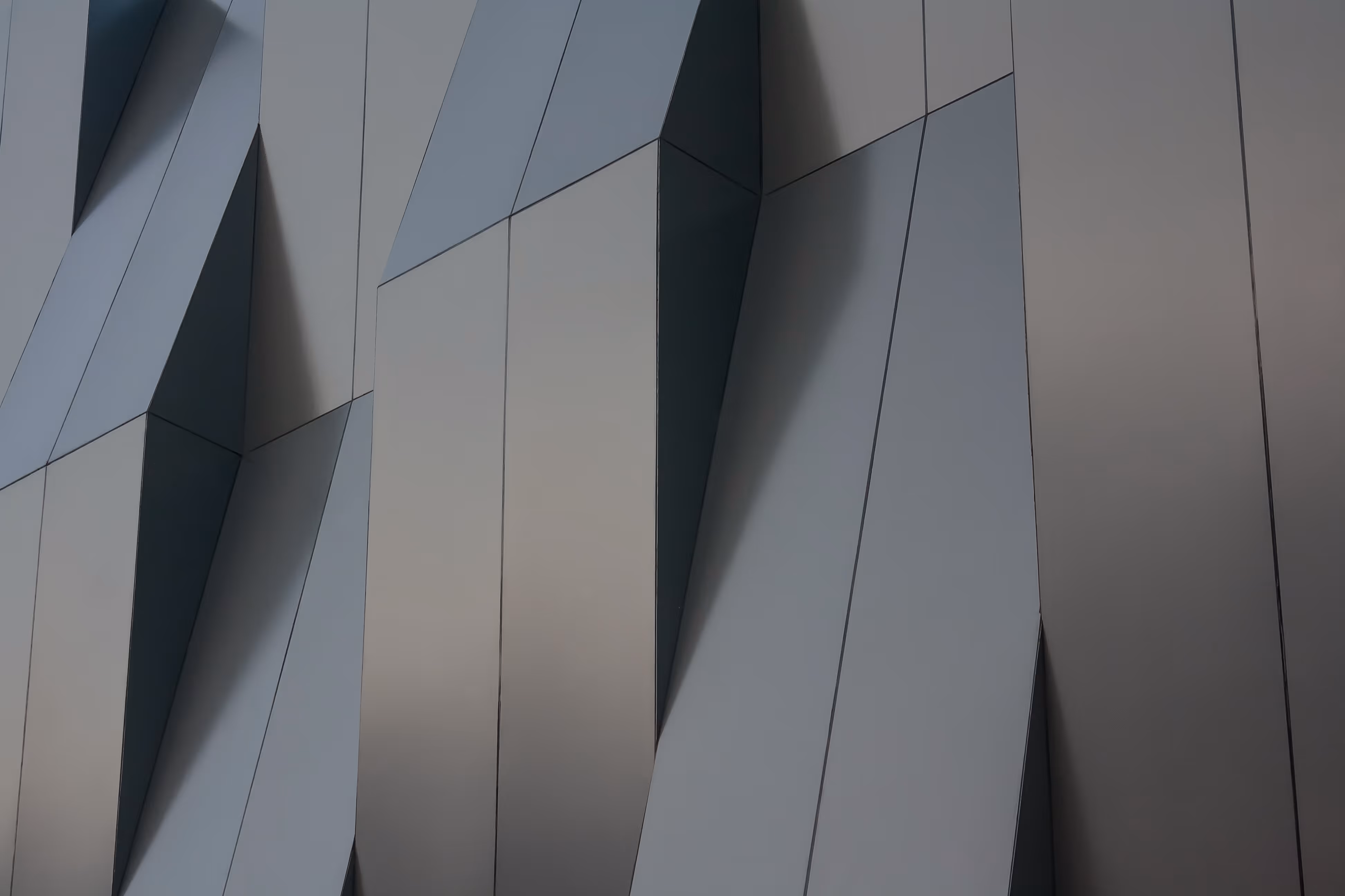 Close-up of a modern building's exterior featuring geometric, angular grey panels.