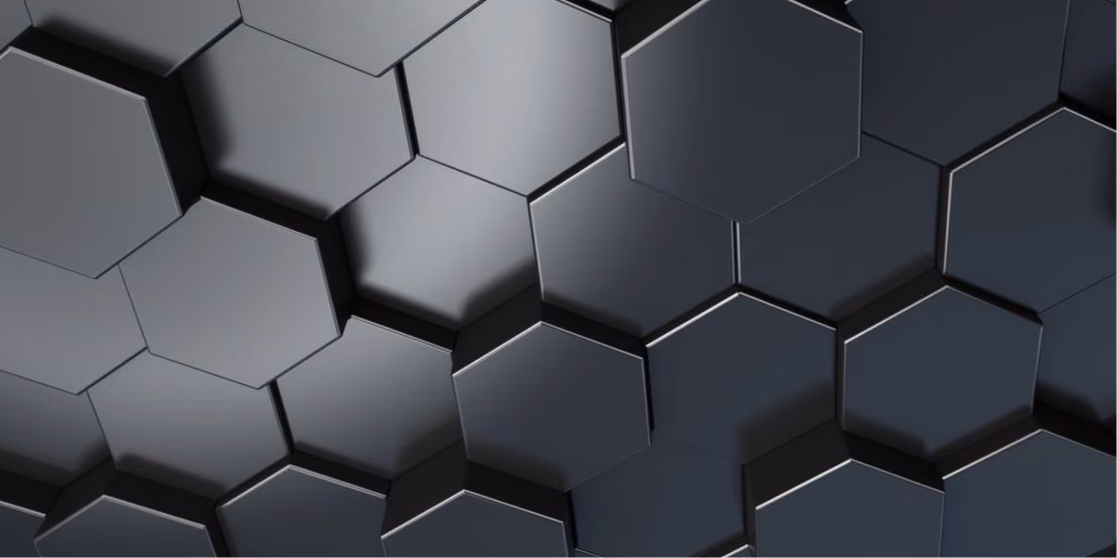 Close-up of a 3D pattern of interlocking hexagonal shapes in varying shades of dark gray and black.