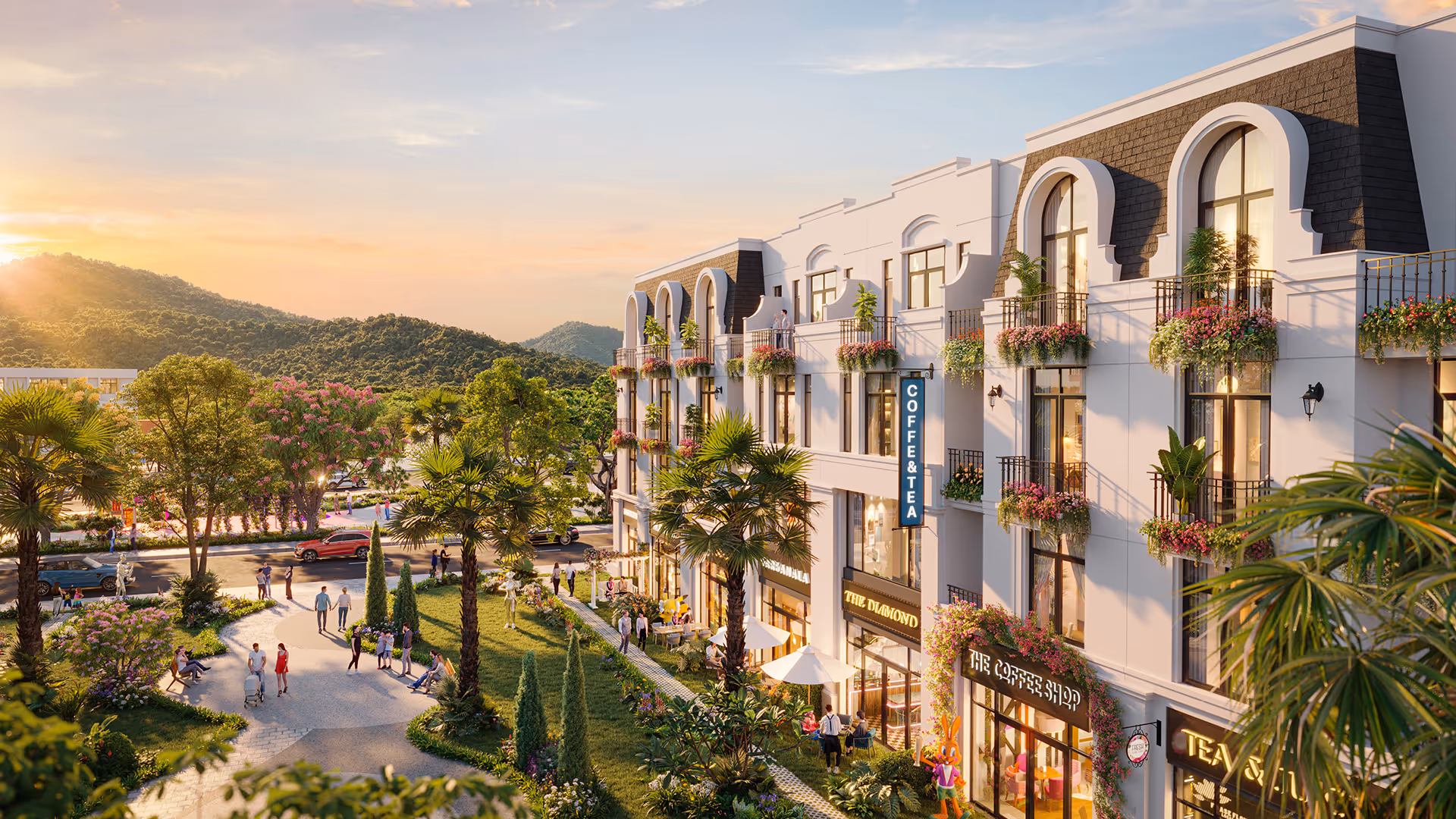 Outdoor scene of a white multi-story building with balconies adorned with flowers, a coffee shop and tea shop at ground level, people walking and sitting in a garden area with palm trees, and hills in the background at sunset.