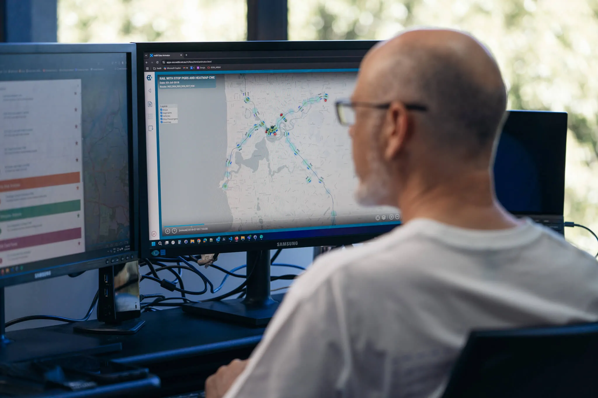 Transport analyst reviewing live route data on dual monitors