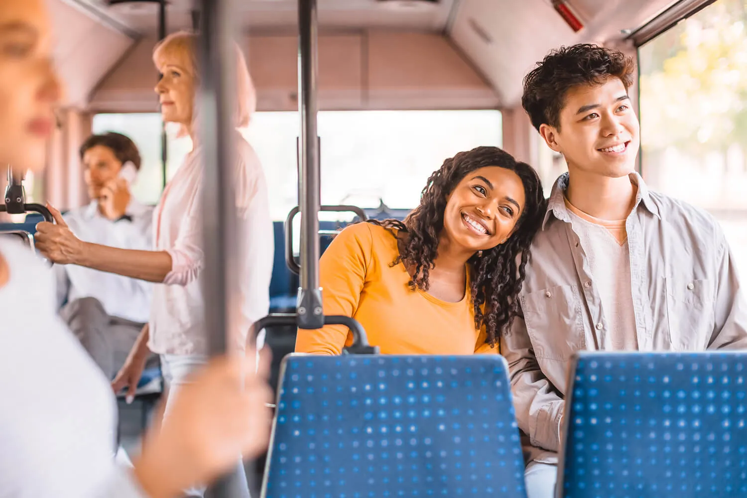 Couple smiling and seated together on a city bus