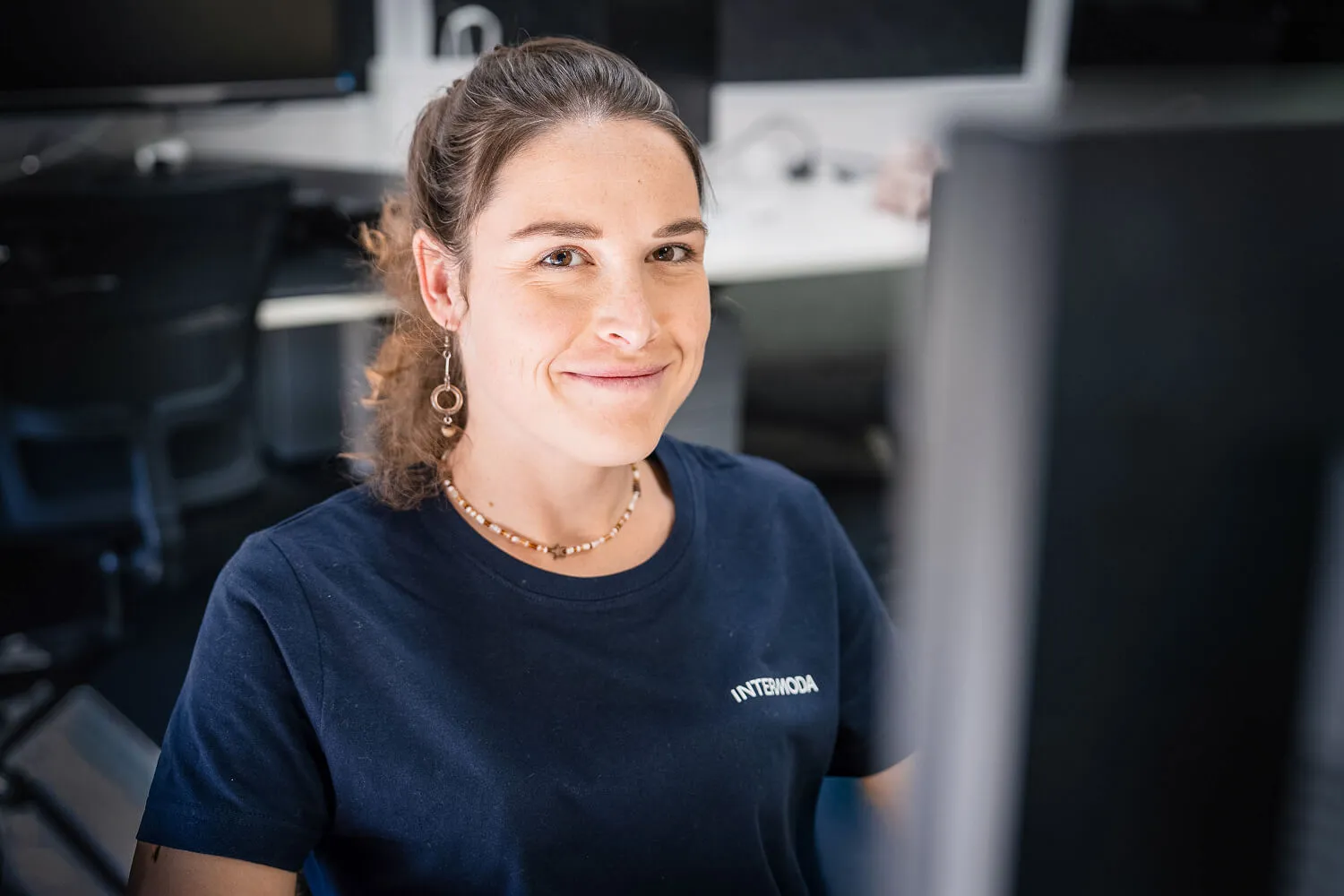 Smiling Intermoda team member at workstation in modern office