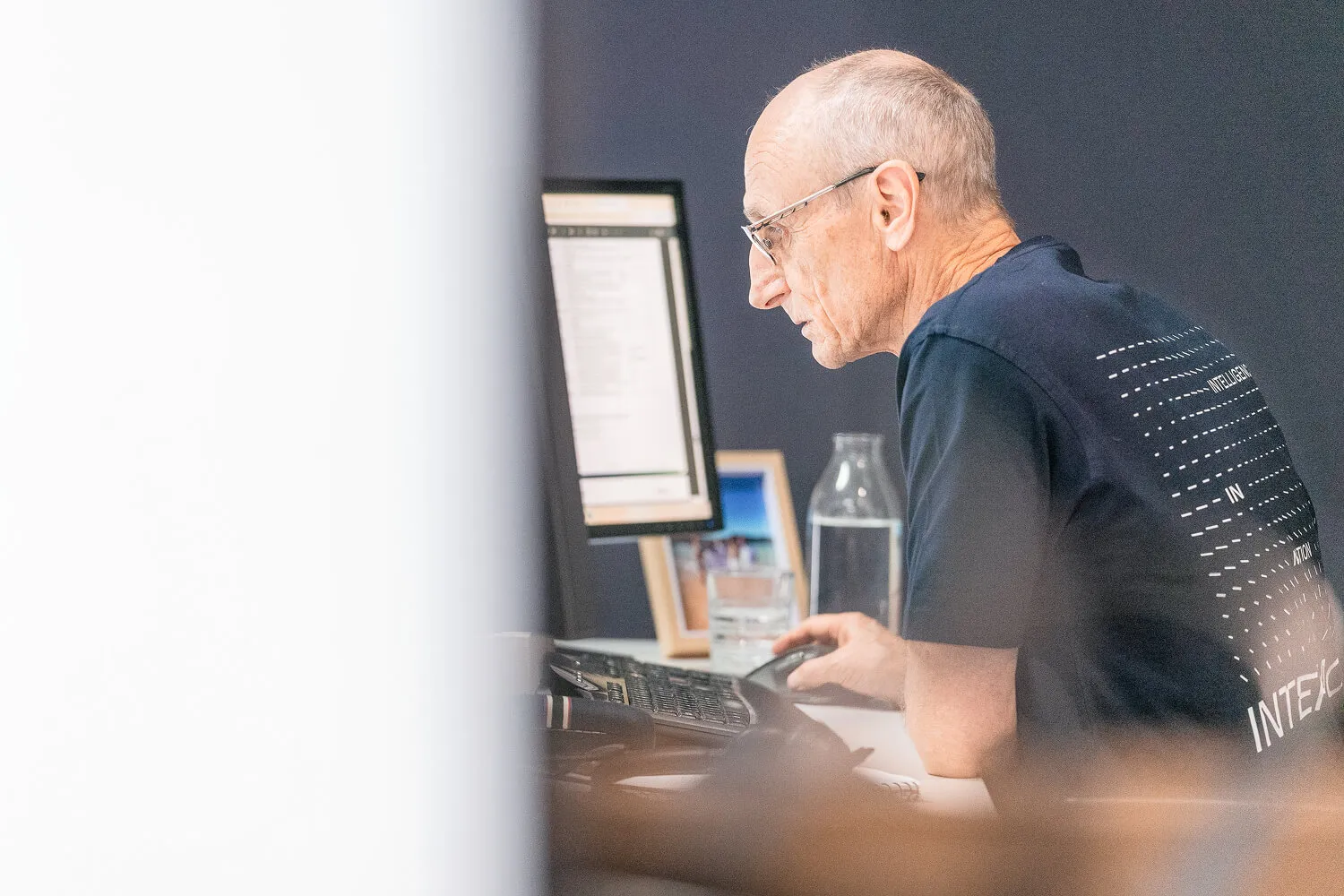 Focused Intermoda employee working at computer in modern office