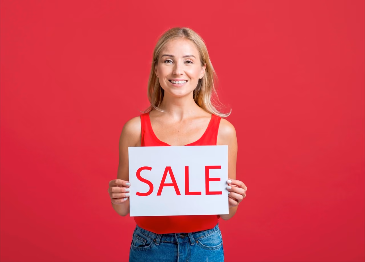 Woman holding a 'Sale' sign promoting discounts and special offers