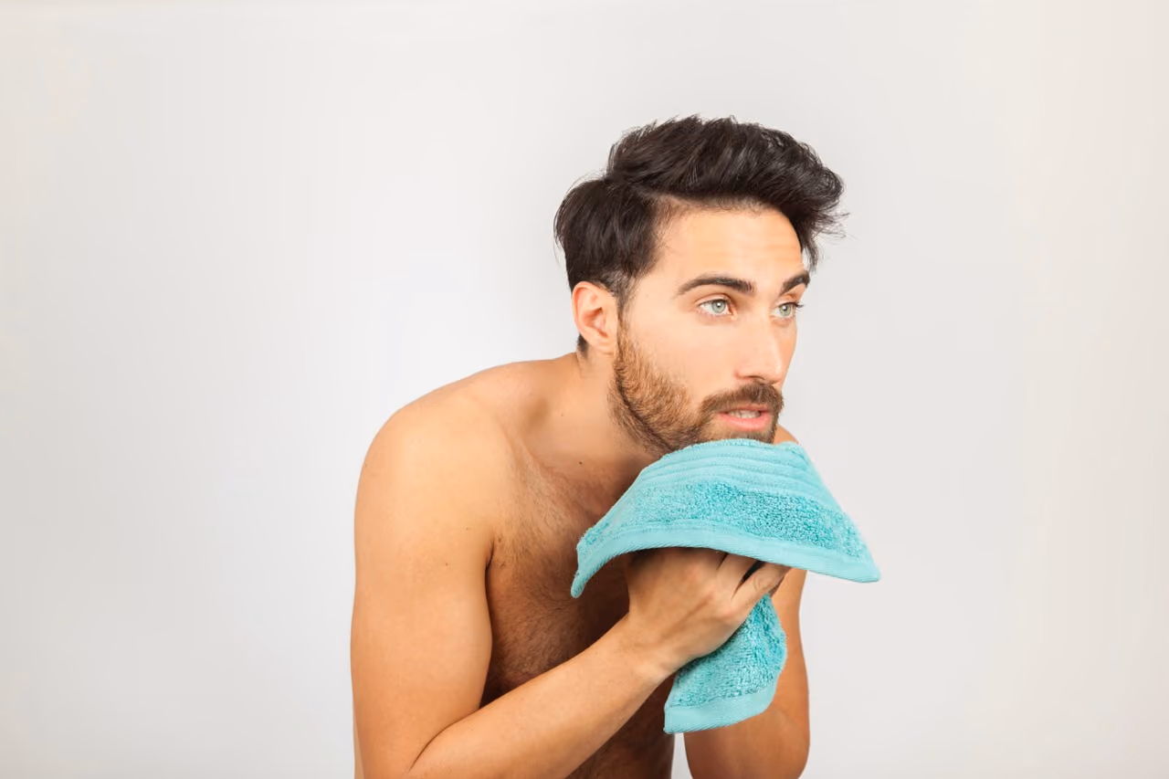 Guy drying face with towel, personal care and grooming routine